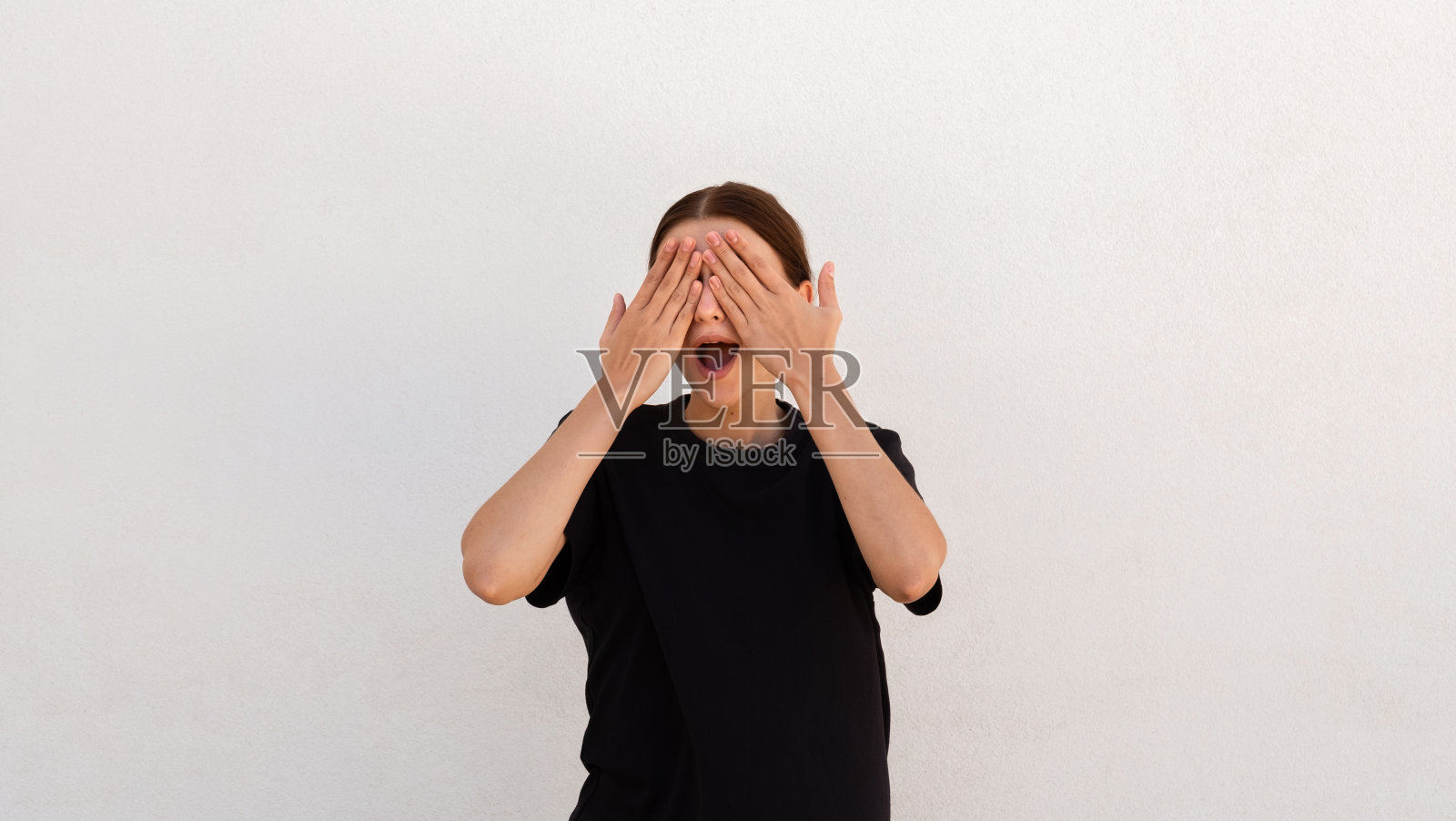 兴奋的年轻女子用手遮住眼睛的肖像照片摄影图片