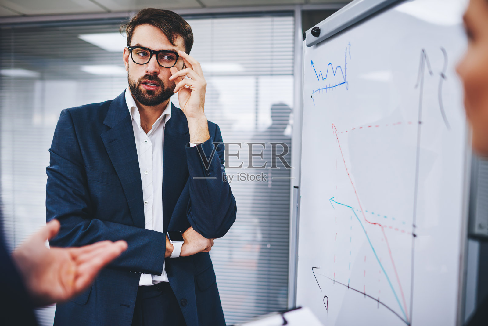 骄傲的ceo穿着西装，在办公室合伙人会议上讨论挂图中的财务图表，分析利润策略，戴眼镜的专业男教练主持商业研讨会照片摄影图片