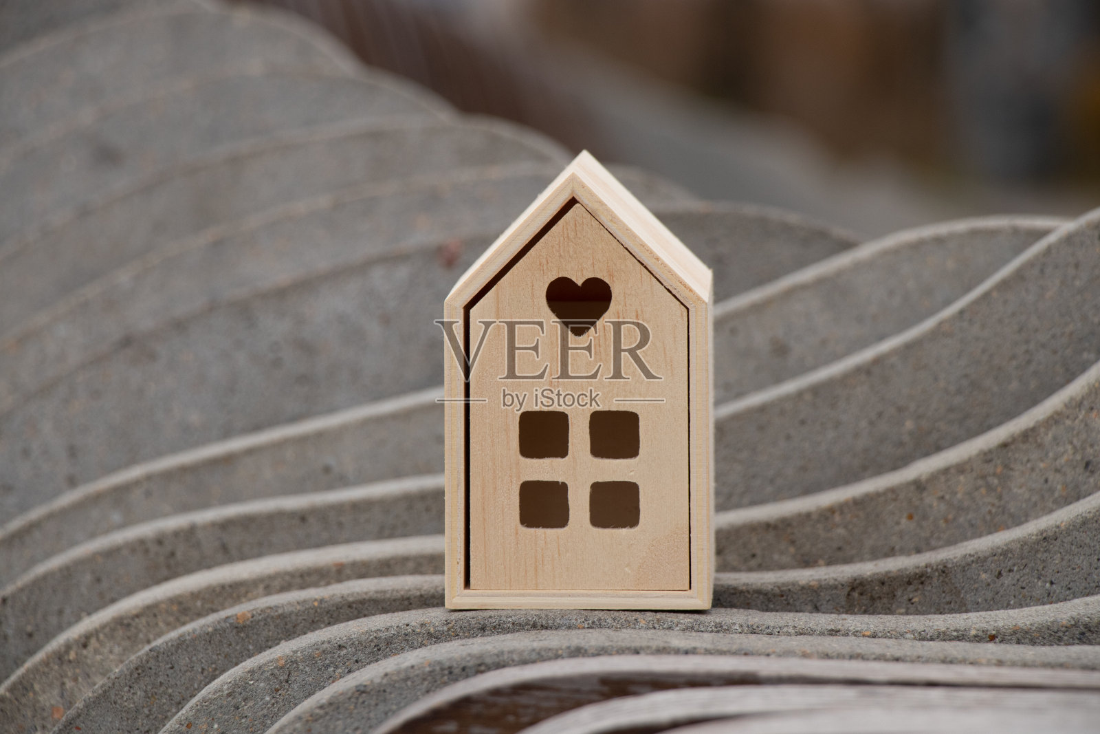 一间小木屋矗立在条纹波状的石头背景上照片摄影图片