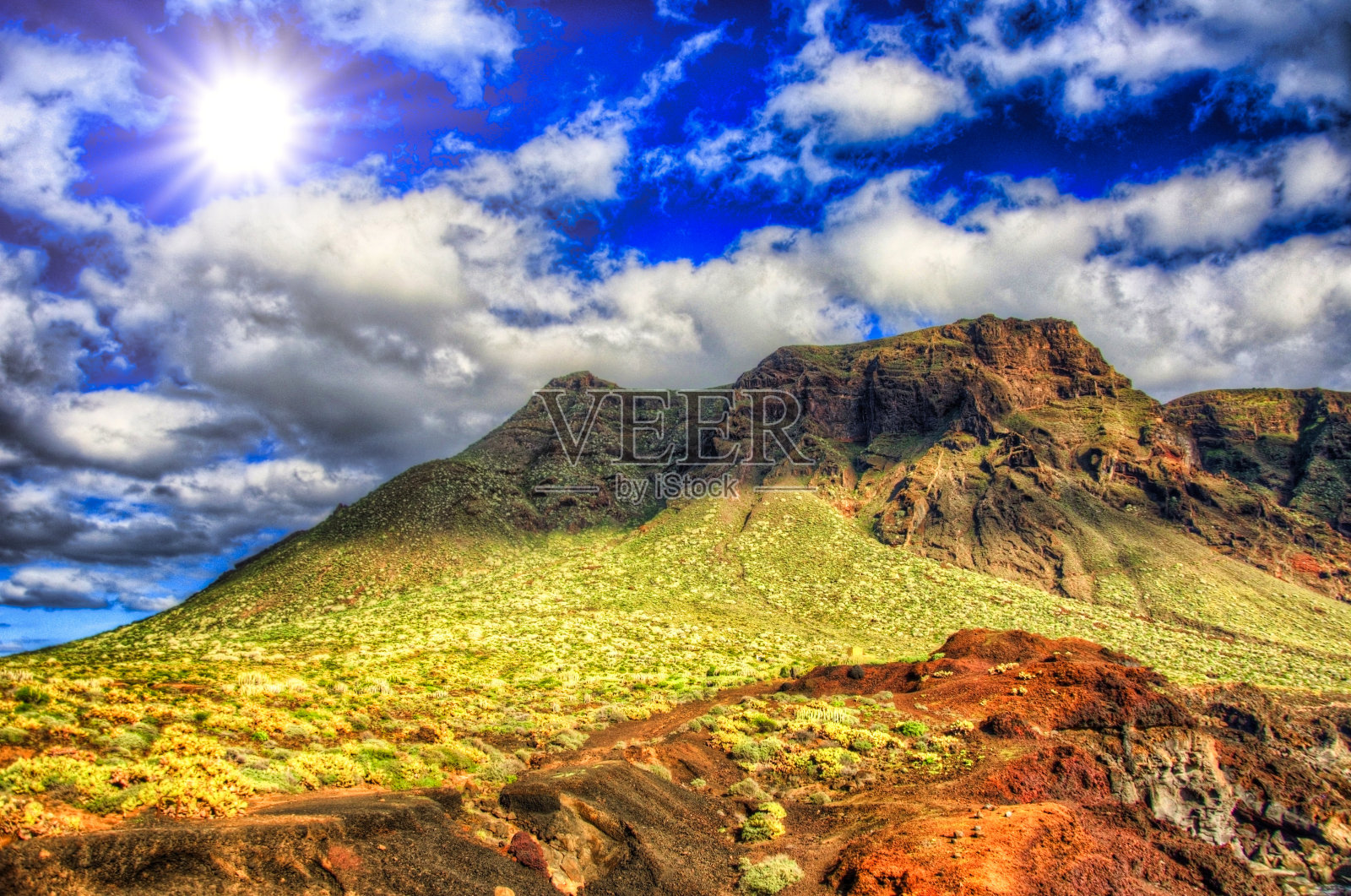 晴朗的日子里，蓝天中的云和绿色的田野和山脉，卡纳利岛特内里费岛西北海岸Punto Teno灯塔附近照片摄影图片