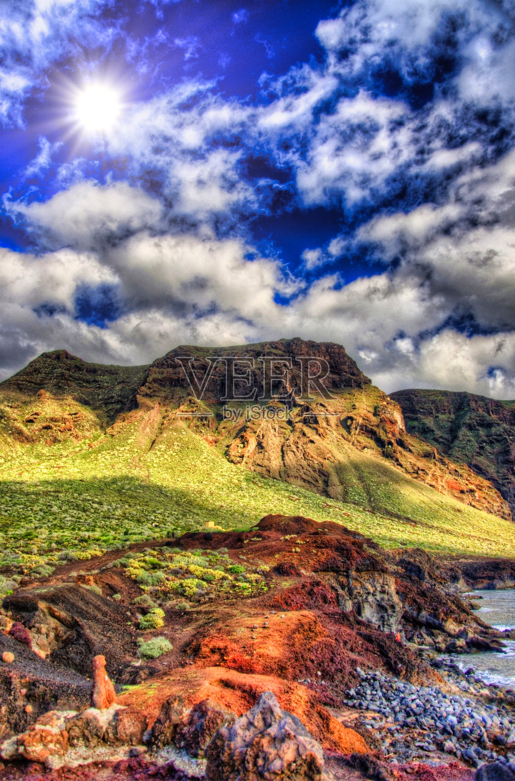 晴朗的日子里，蓝天中的云和绿色的田野和山脉，卡纳利岛特内里费岛西北海岸Punto Teno灯塔附近照片摄影图片