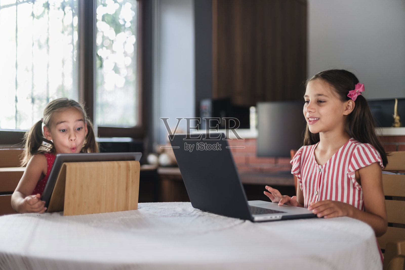 儿童在家中使用笔记本电脑和数字平板电脑，跨设备组概念照片摄影图片