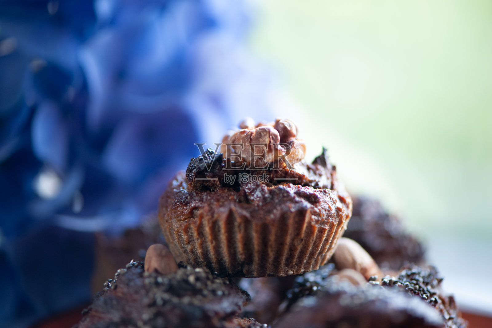 纸杯蛋糕，烘焙概念。时髦的纸杯蛋糕放在盘子里，周围是蓝色的绣球花。照片摄影图片