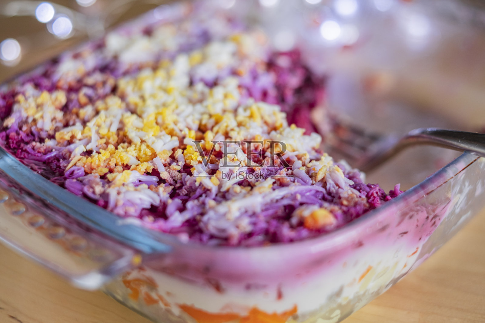 分层沙拉鲱鱼皮草外套在桌子上。一份传统的俄罗斯沙拉，有鲱鱼，甜菜，胡萝卜和鸡蛋照片摄影图片