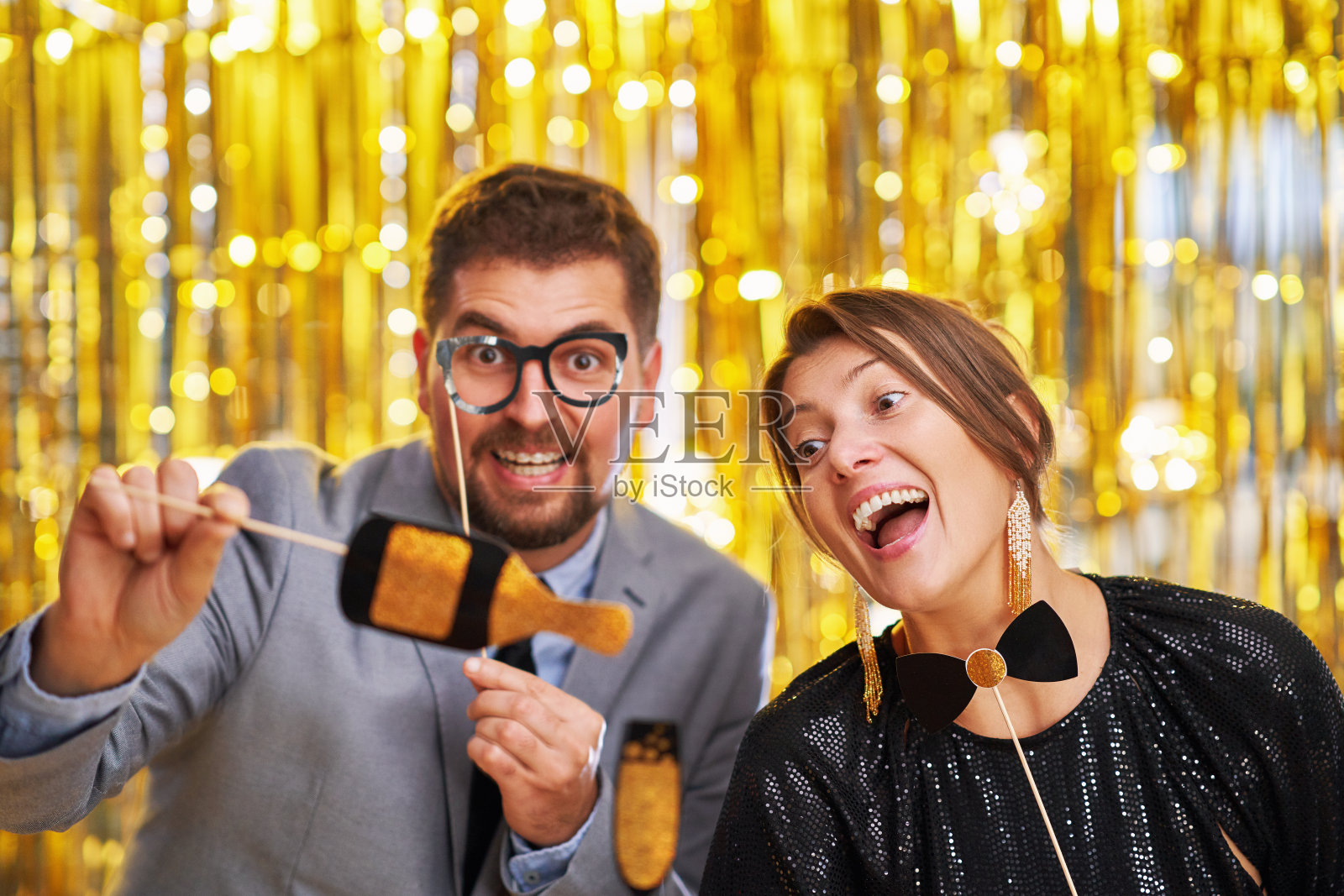 一对金色情侣，派对上有照相亭配件照片摄影图片