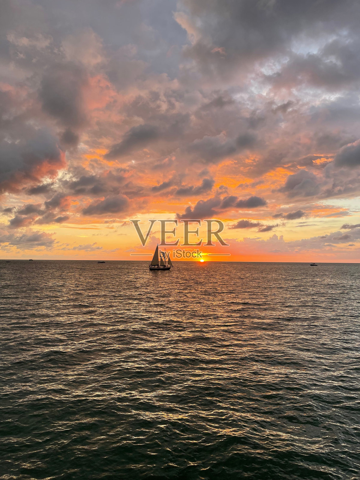 垂直拍摄的一艘船在海上日落照片摄影图片