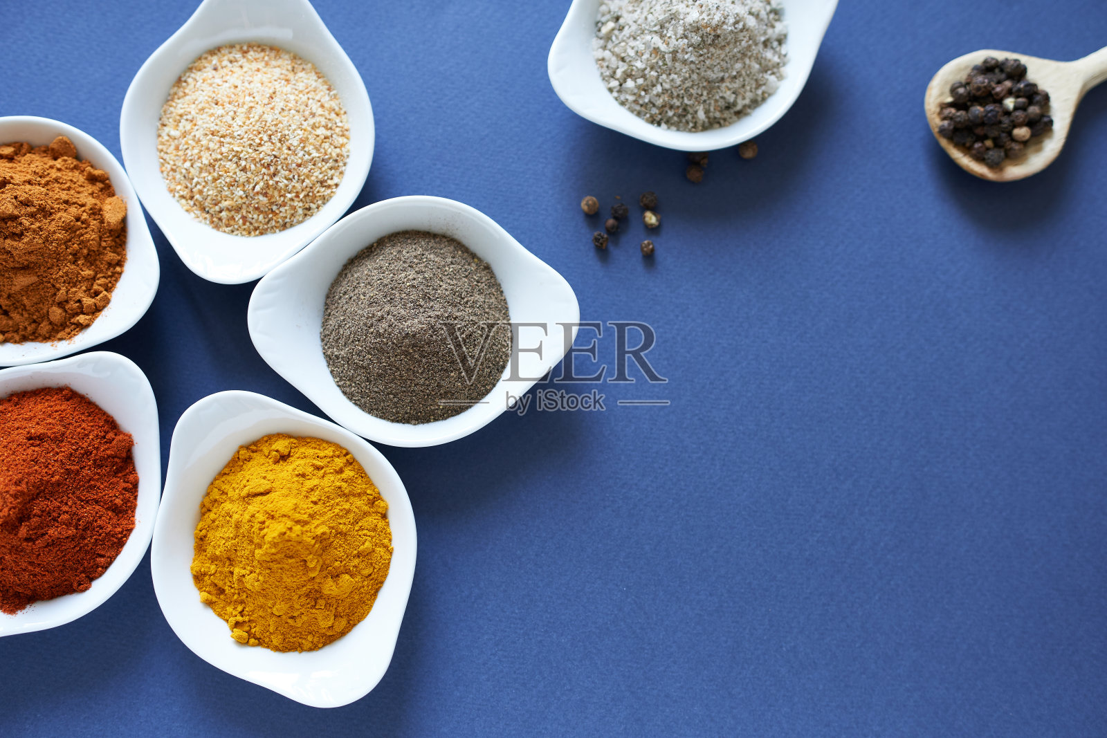 蓝色背景上有不同的香料，文本空白。照片摄影图片