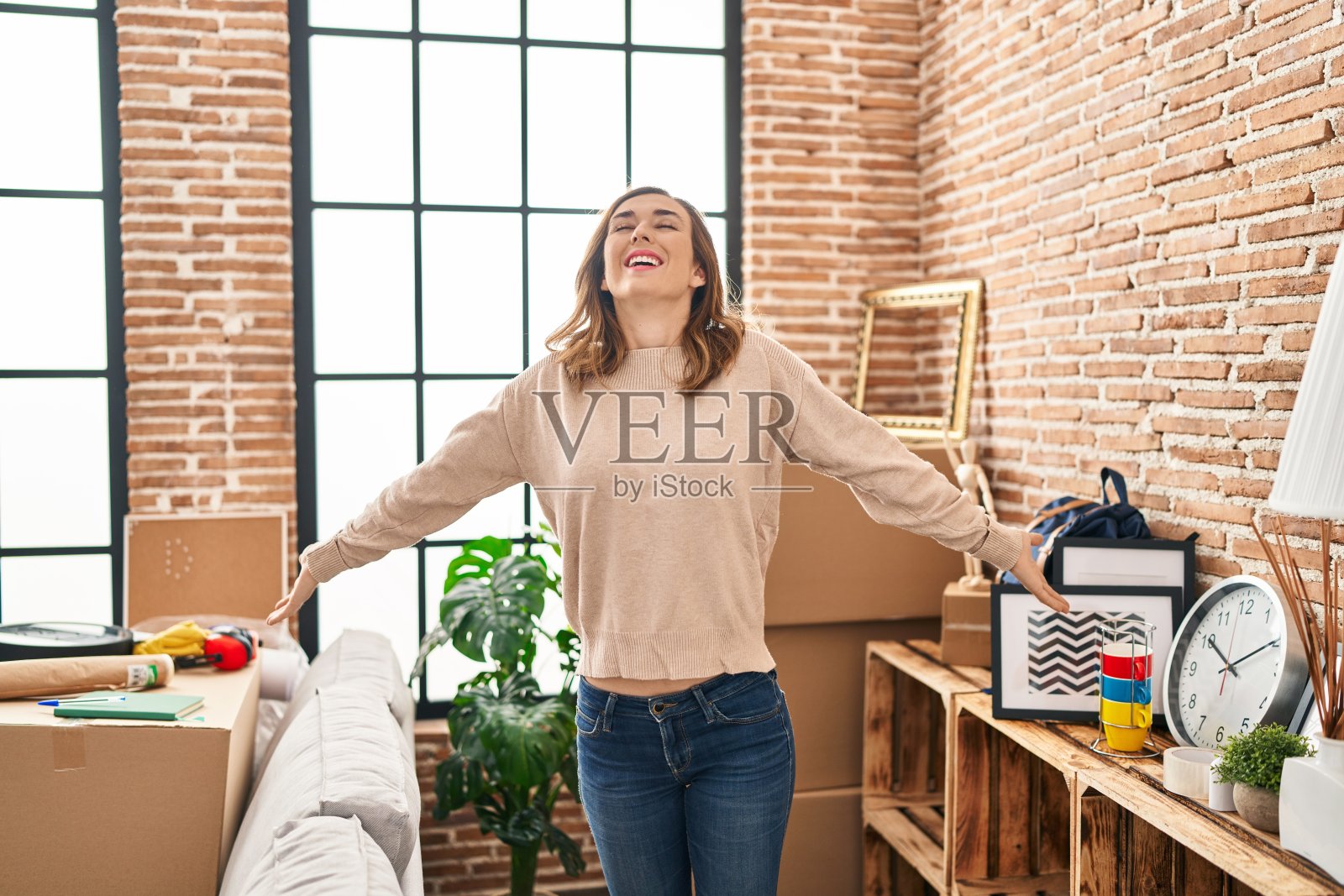 年轻女子在新家张开双臂呼吸照片摄影图片