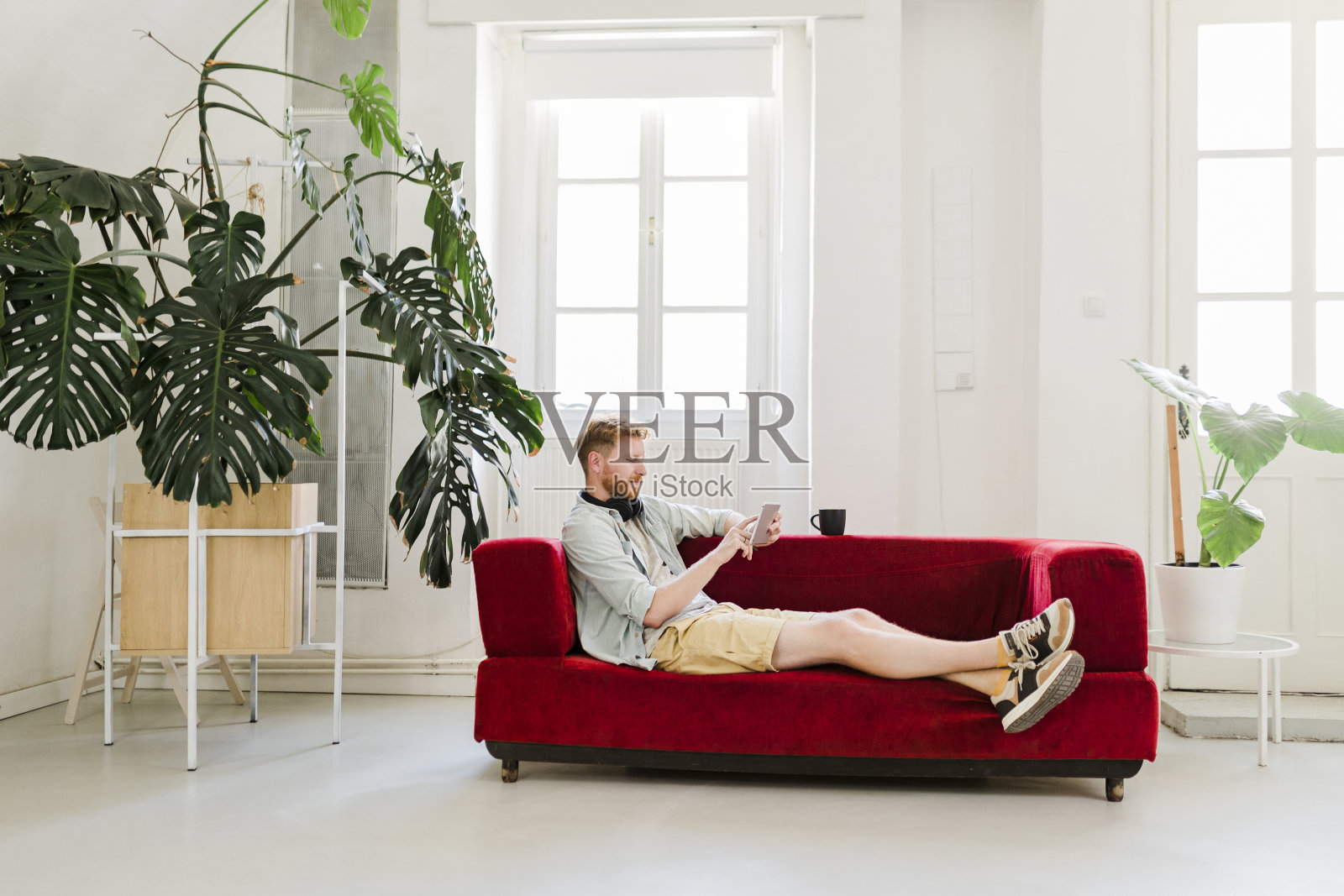 成熟的姜商人在家里喝着咖啡，用平板电脑工作照片摄影图片