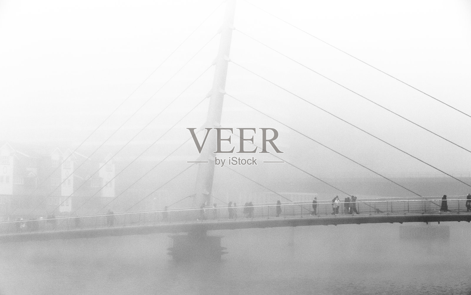 在大雾天，英国伦敦市中心，通勤者走过桥照片摄影图片