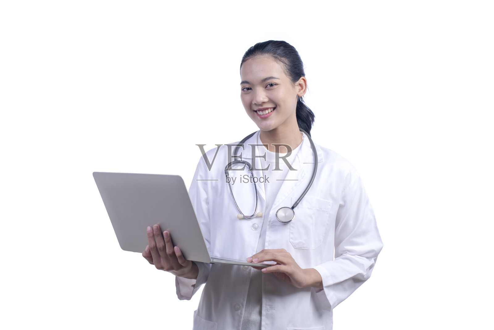 年轻的亚洲医生女听诊器拿着笔记本电脑微笑着看着相机。孤立在白色背景上。照片摄影图片