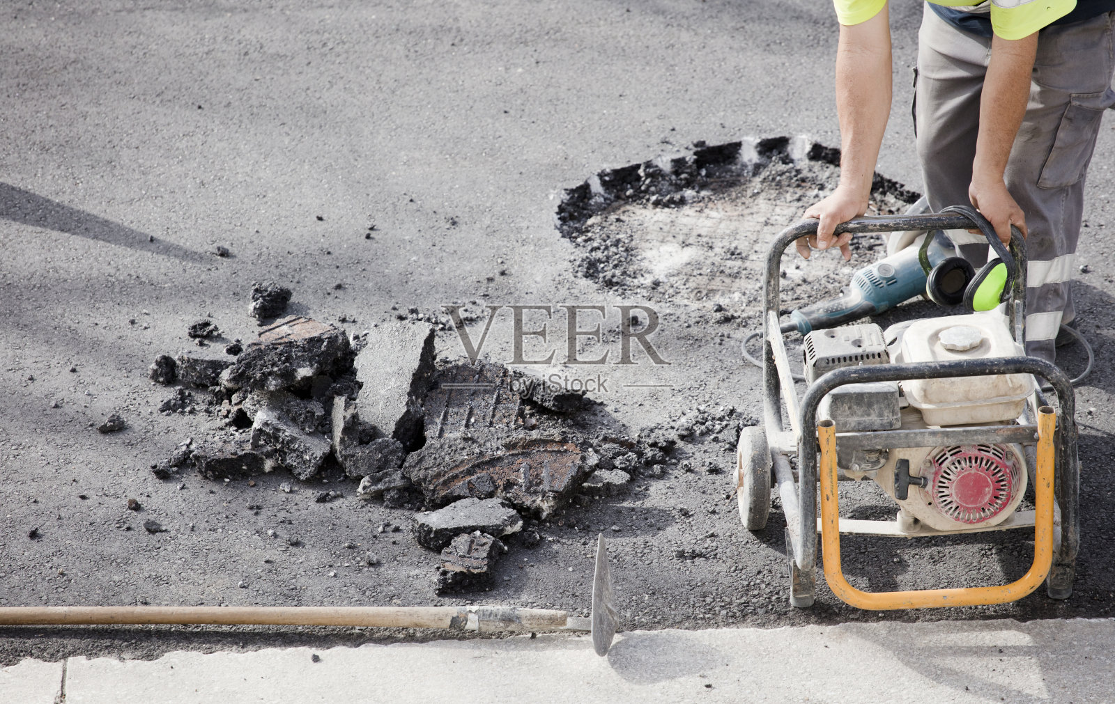 身着制服的工人和发电机在工地上涂沥青照片摄影图片