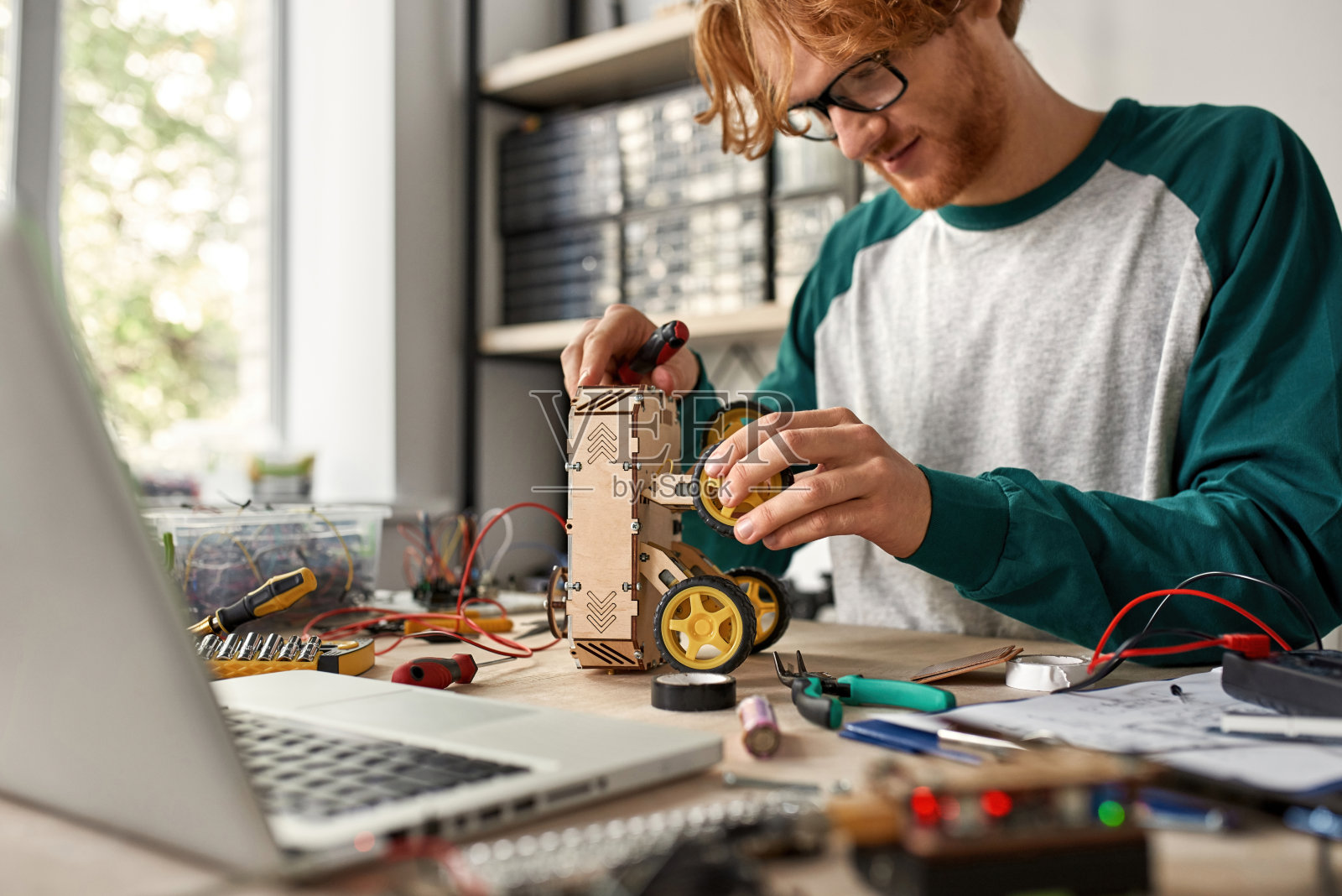 男性IT工程师在桌子上检查轮子机器人照片摄影图片