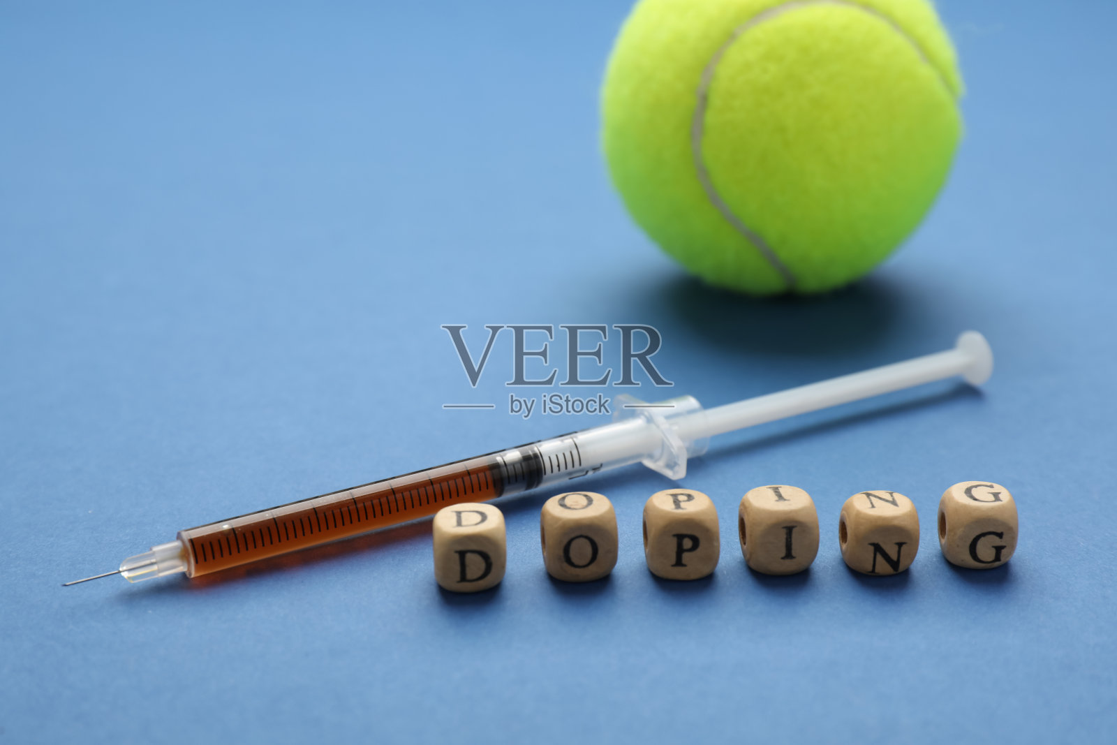 蓝色背景上有“兴奋剂”、“注射器”和“网球”字样的木制方块照片摄影图片