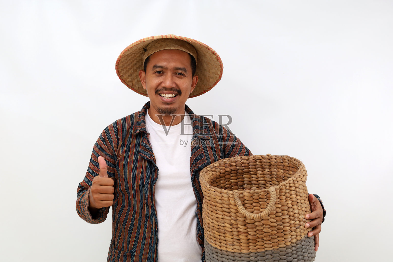 快乐的亚洲农民站着，拿着一个空篮子，竖起大拇指。白色背景隔离照片摄影图片