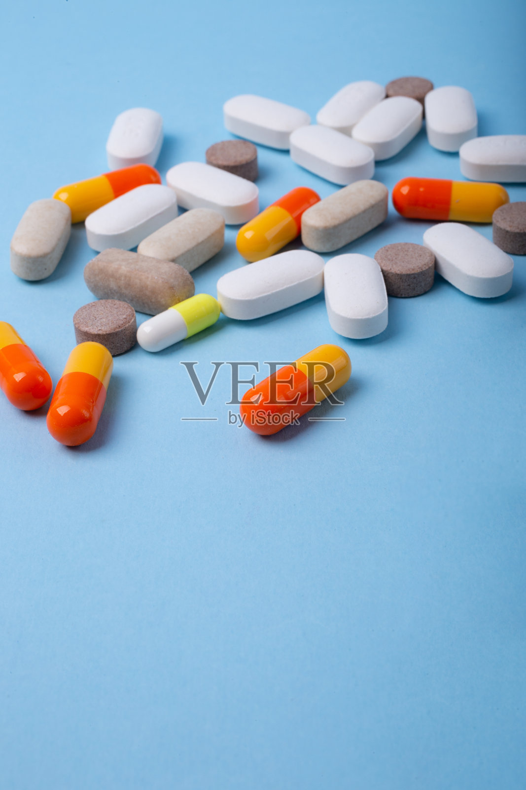 垂直摄影不同药丸在蓝色背景与负空间。照片摄影图片