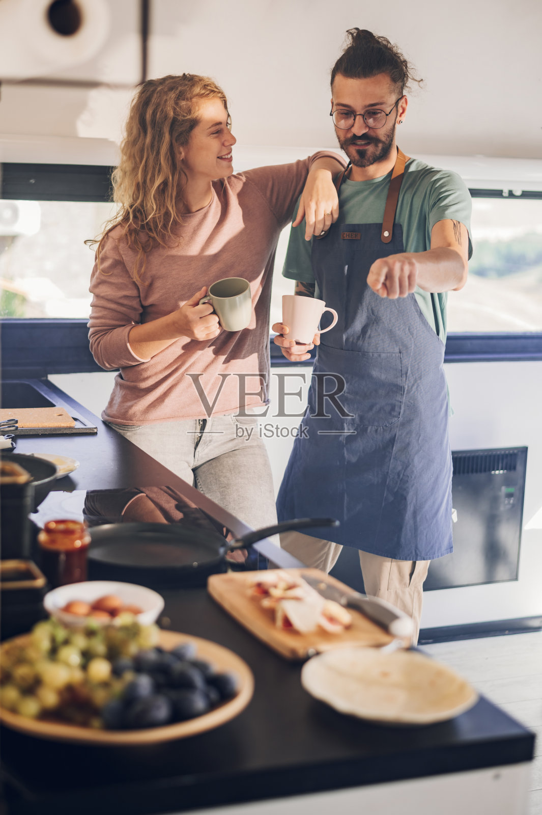 年轻夫妇在家中厨房一起做早餐照片摄影图片