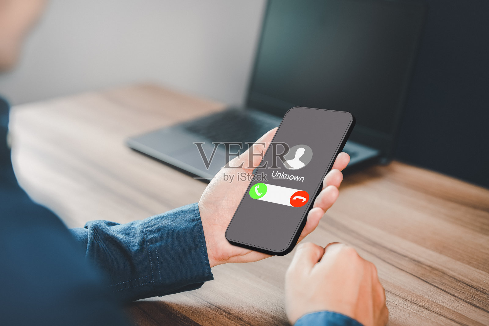 接听来电的男人。未知号码来电。呼叫中心黑帮，骗子或陌生人。使用假身份的骗子。诈骗，诈骗或网络钓鱼与手机或智能手机的概念。照片摄影图片