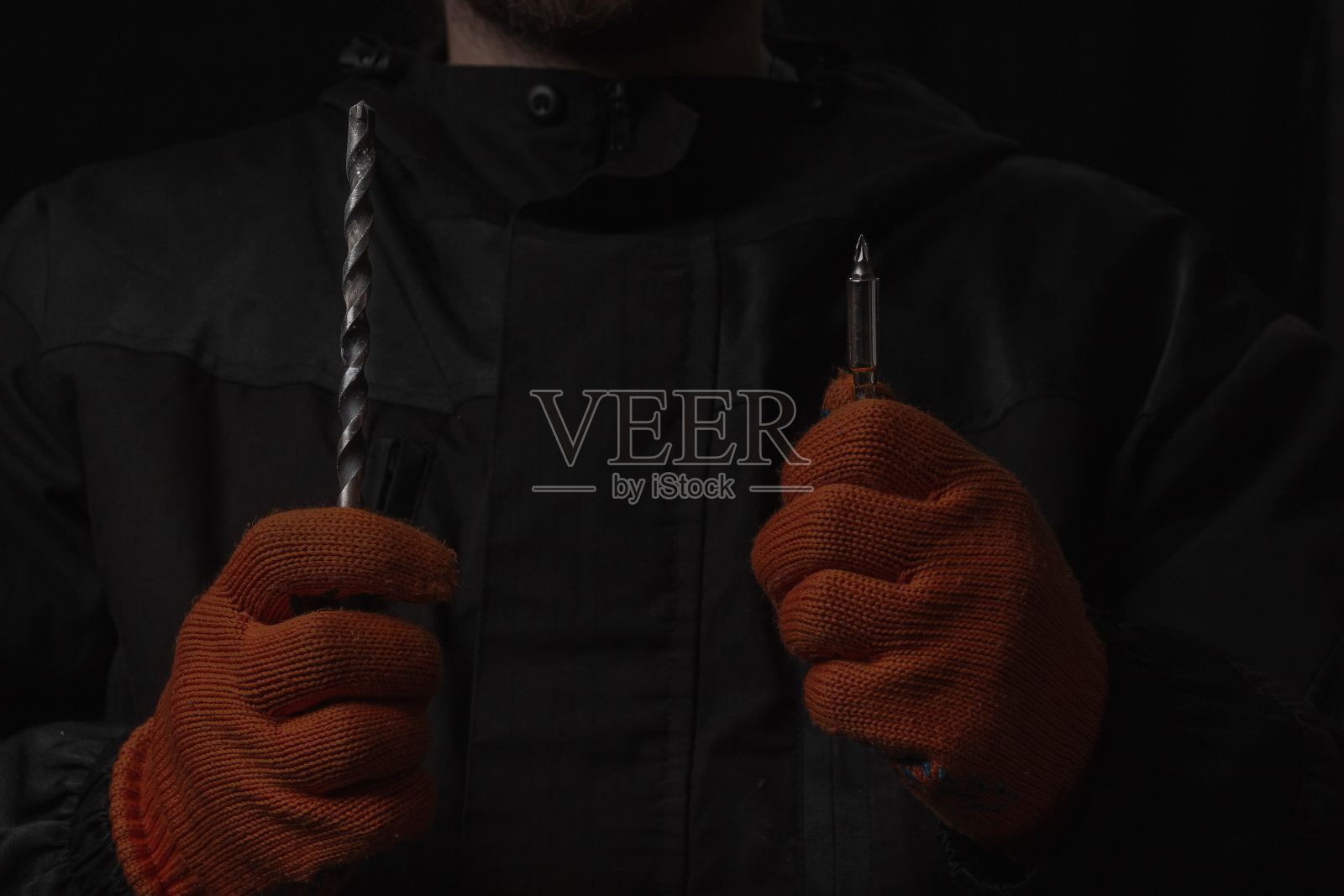 手持无绳电动螺丝刀，螺丝和钻孔钻头隔离在黑色背景上照片摄影图片