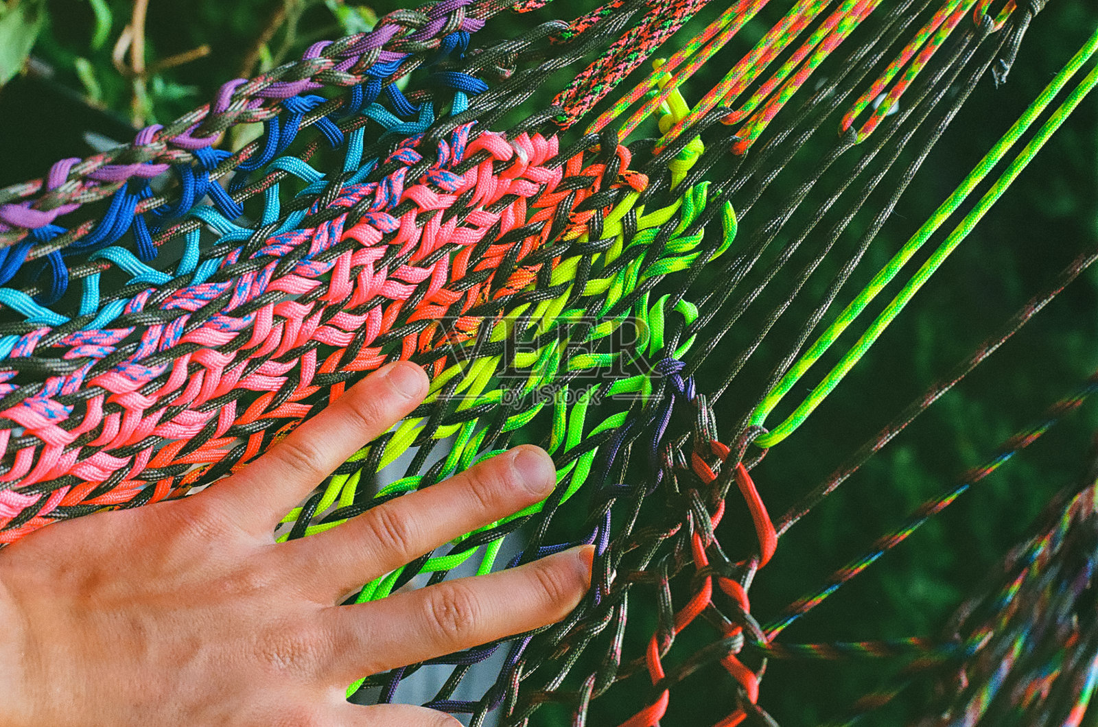 一只手放在彩色吊床上照片摄影图片