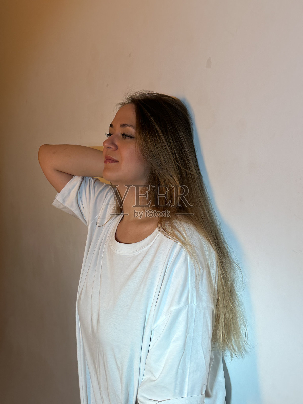 年轻漂亮的女人，长发，绿眼睛，穿着白t恤照片摄影图片