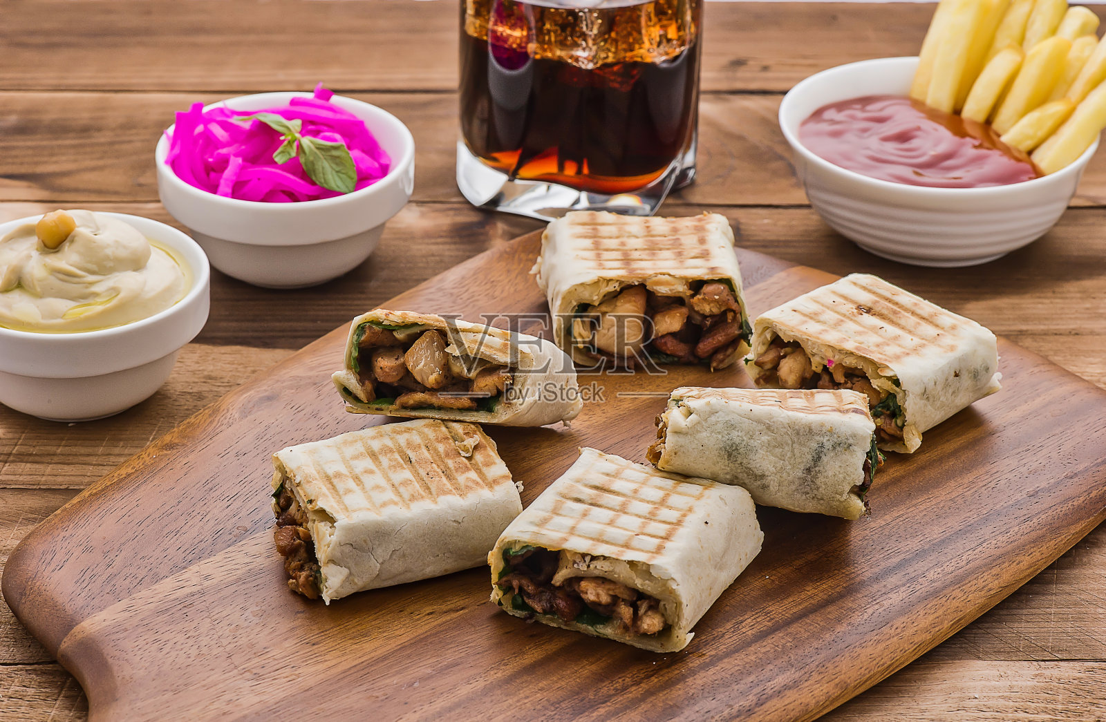 什锦墨西哥卷饼拼盘，配鹰嘴豆泥、番茄酱、炸薯条和冷饮，阿拉伯美食餐桌摆拍照片摄影图片