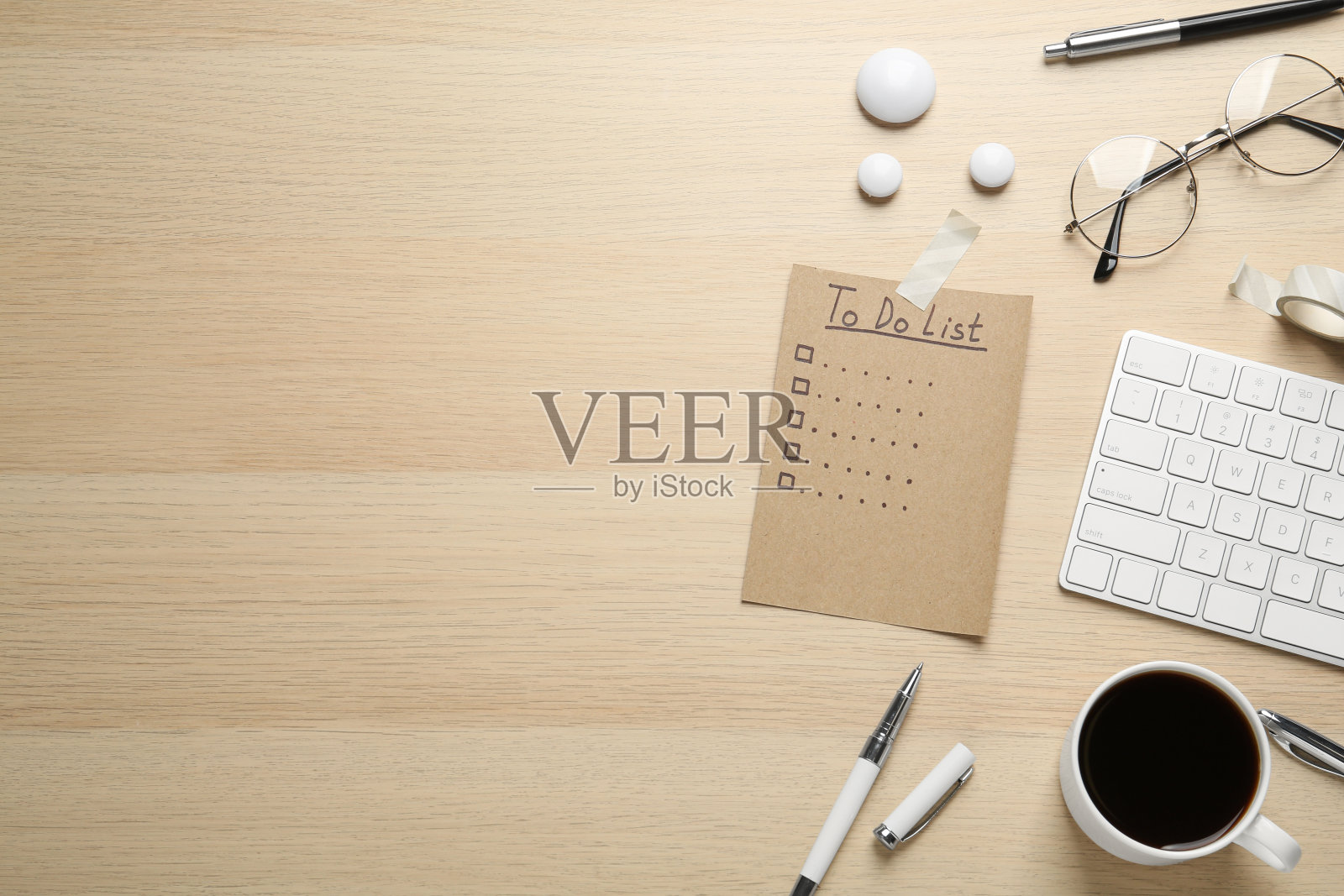 平铺构图，未填写的待办事项清单，一杯咖啡和玻璃杯放在木桌上。文本空间照片摄影图片