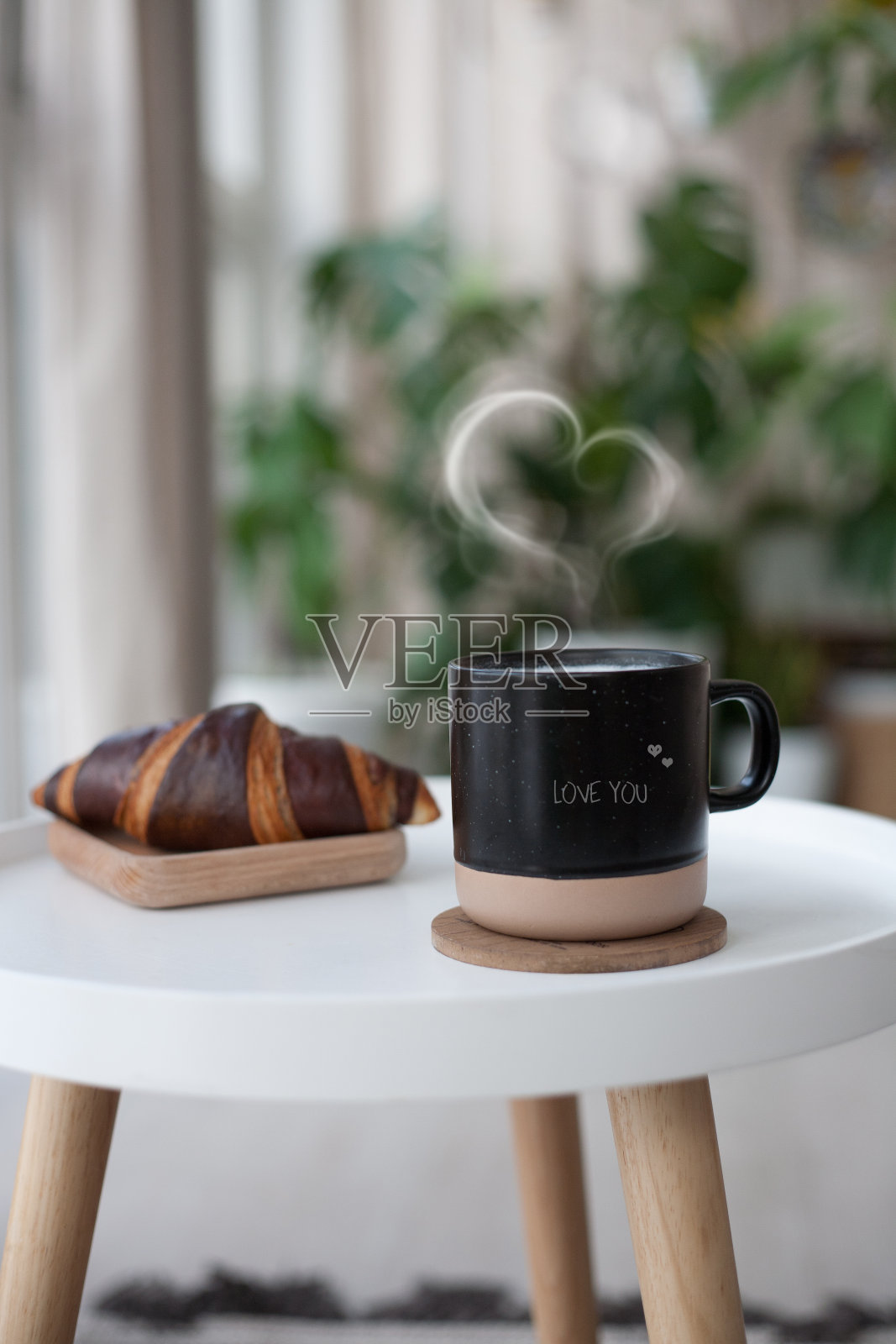 心形咖啡和牛角包放在白色的桌子上。法国早餐。复制文本空间照片摄影图片