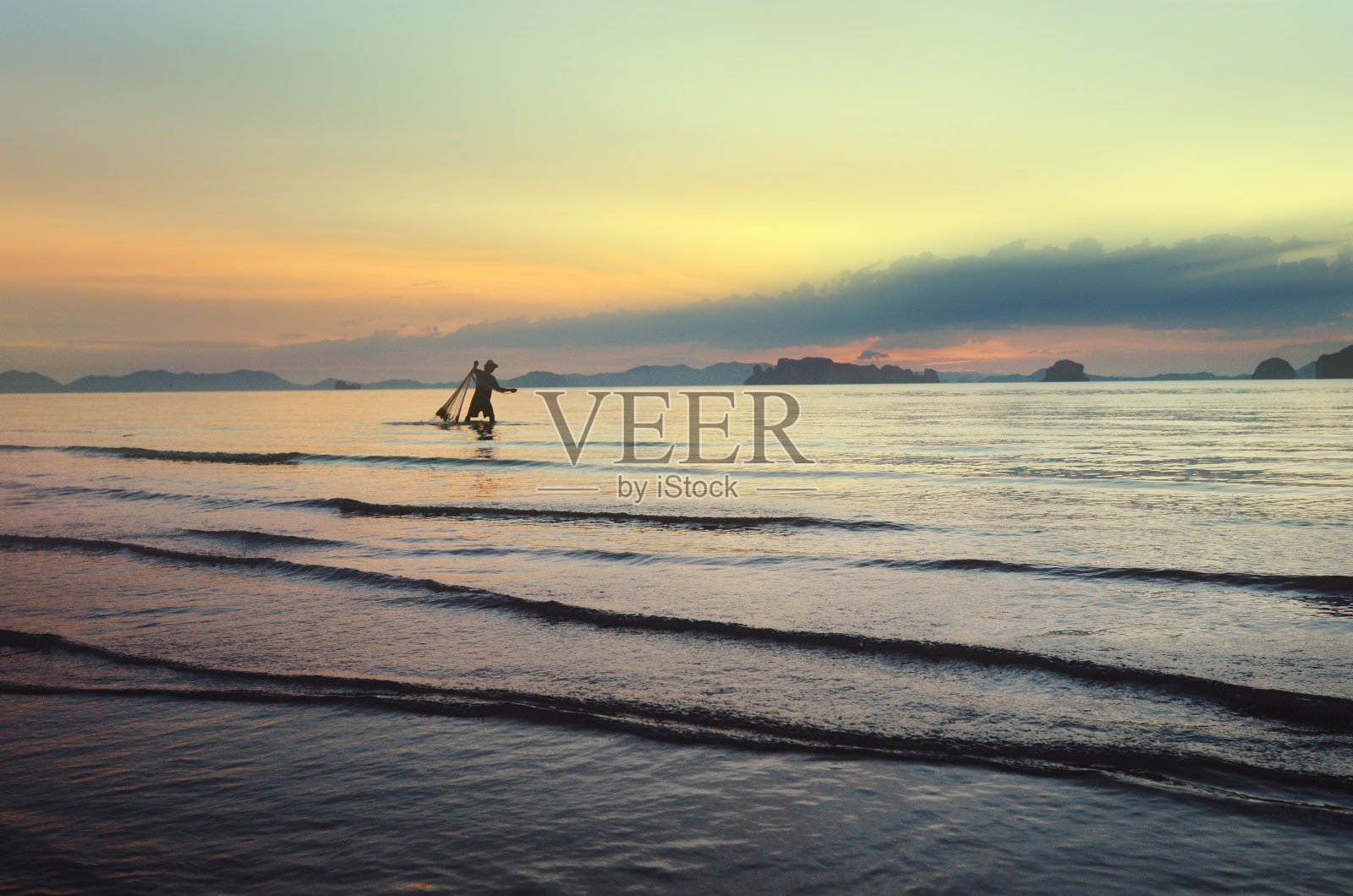 渔夫在日落时分钓鱼。传统的泰国捕鱼。泰国。甲米省。退潮时的异国情调的泰国海滩和海湾的美丽景色。美丽放松的自然背景照片摄影图片