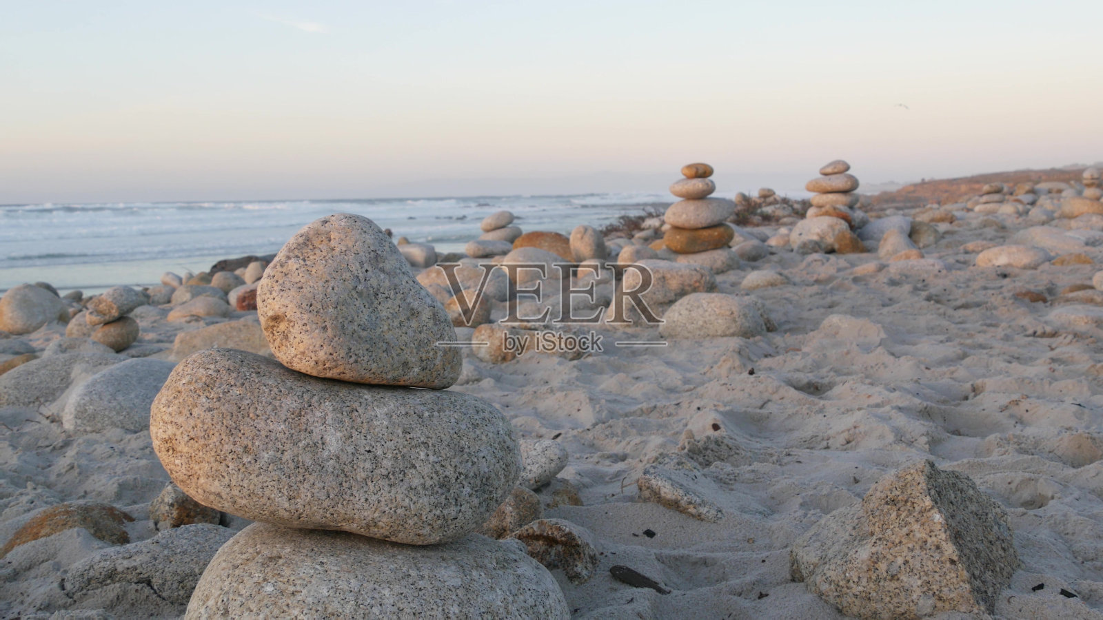 卵石海滩上的岩石平衡。金字塔的石头堆，海岸，海水照片摄影图片