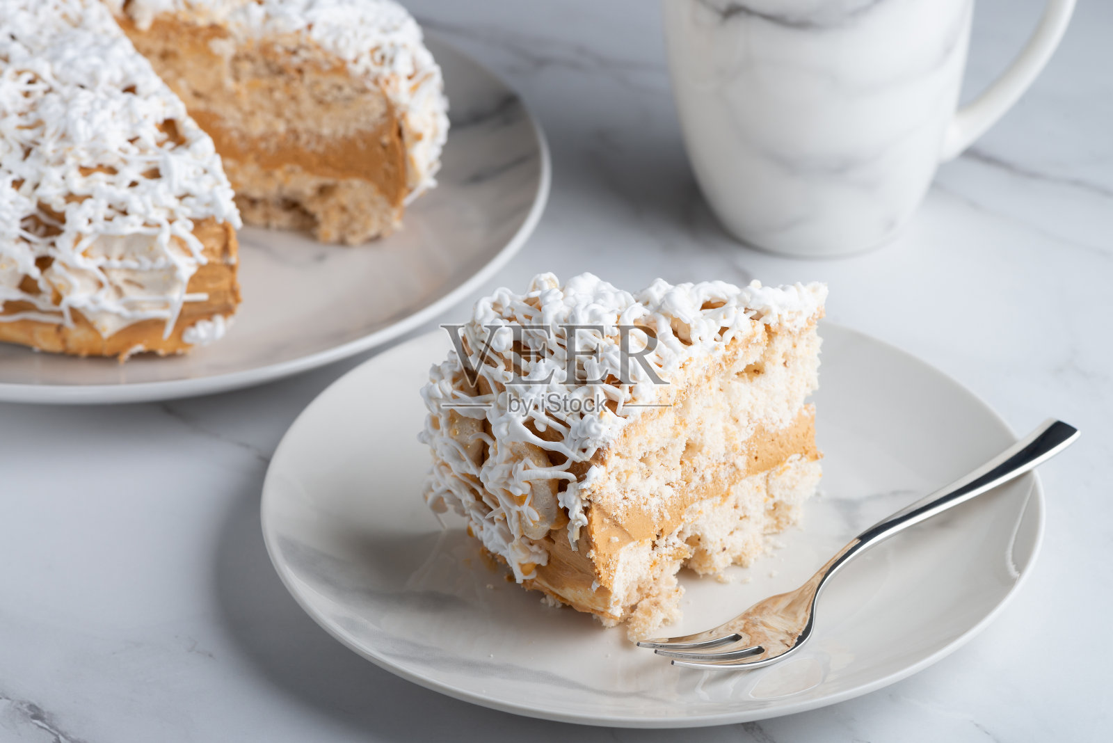 一块美味的香草蛋糕和蛋糕放在一张浅色的桌子上照片摄影图片