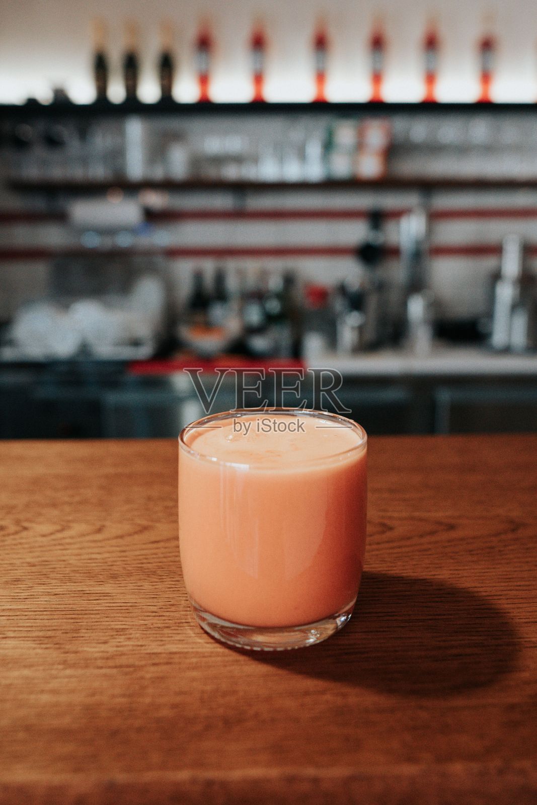 酒吧桌子上的一杯果汁特写。水果鸡尾酒。照片摄影图片