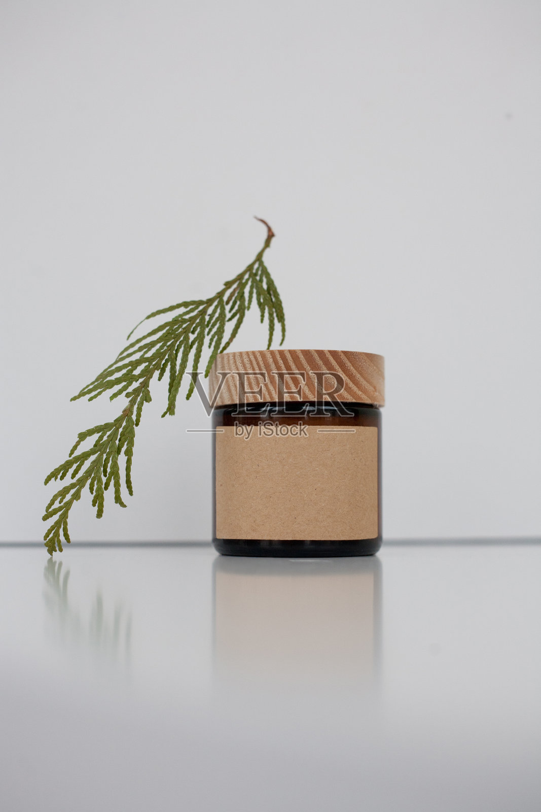 一个化妆品暗琥珀色玻璃罐与牛皮纸标签，极简主义品牌包装模拟照片摄影图片