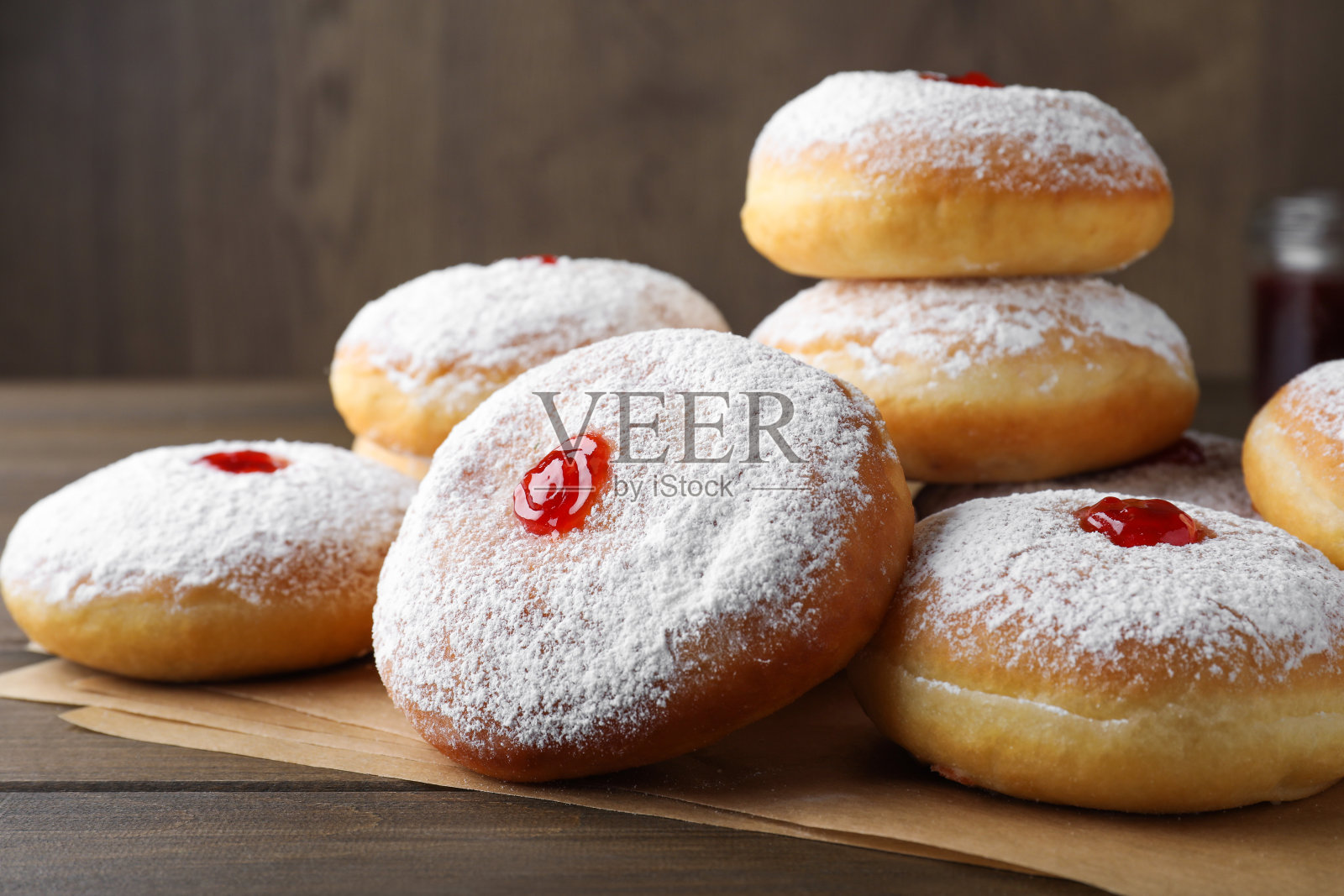 许多美味的甜甜圈，果冻和糖粉放在木桌上，特写照片摄影图片