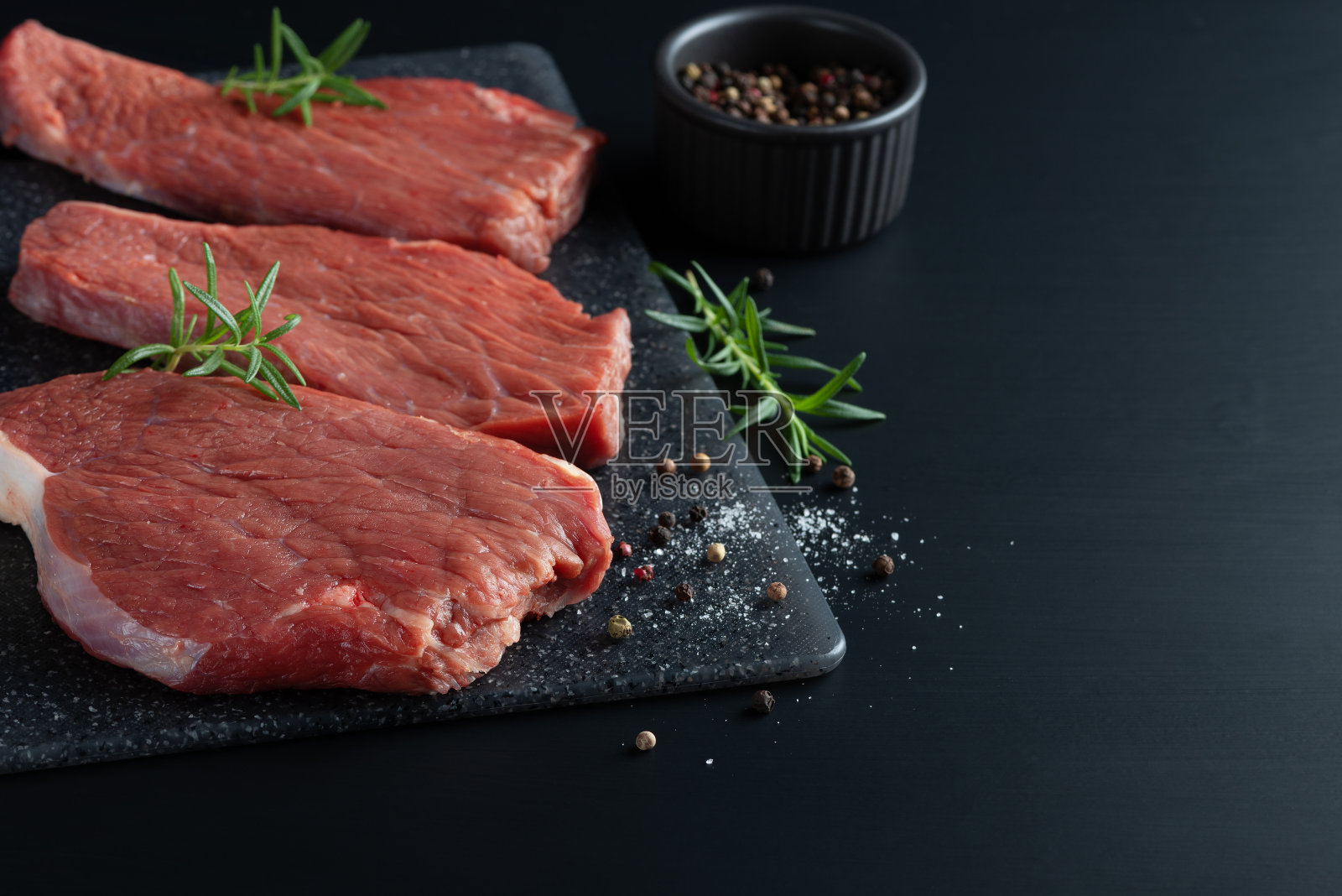 新鲜生牛里脊配迷迭香照片摄影图片