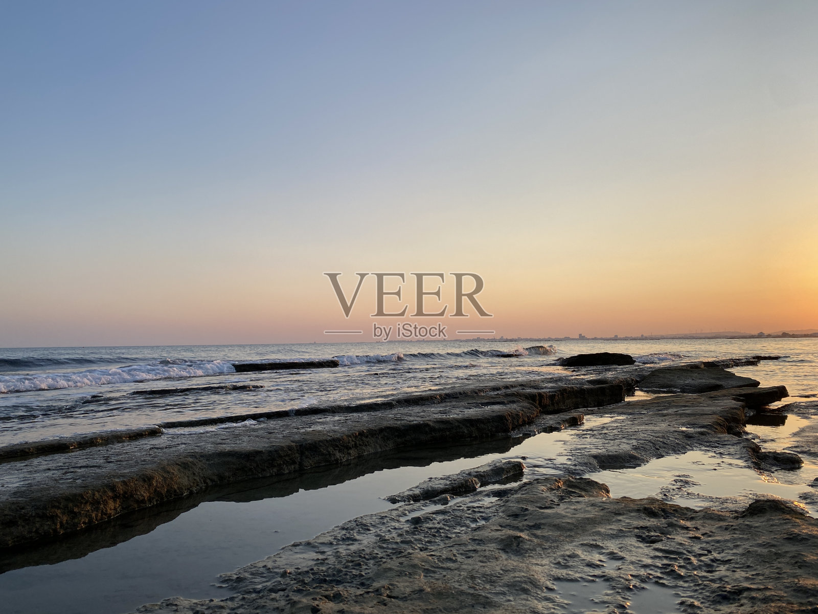 地中海海滩日落与礁石照片摄影图片