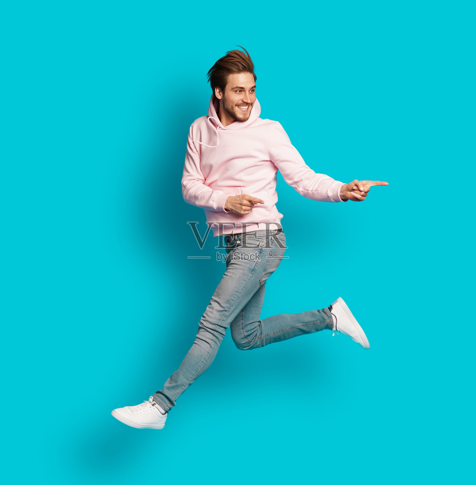全尺寸的照片，年轻的快乐兴奋的微笑积极的男子跳跃孤立在浅蓝色的背景。照片摄影图片