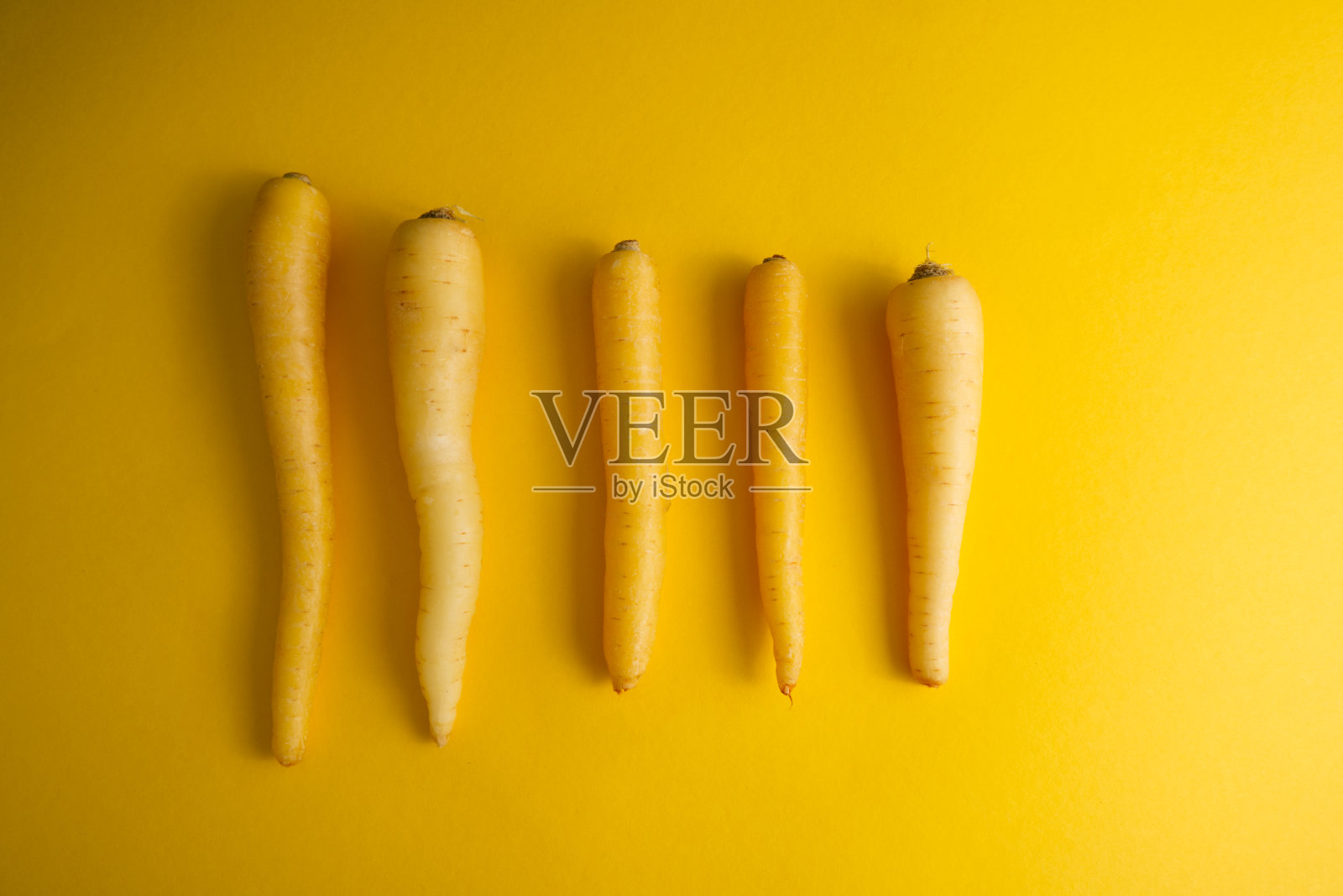 黄色的胡萝卜平行排列在黄色背景的顶视图复制空间上照片摄影图片