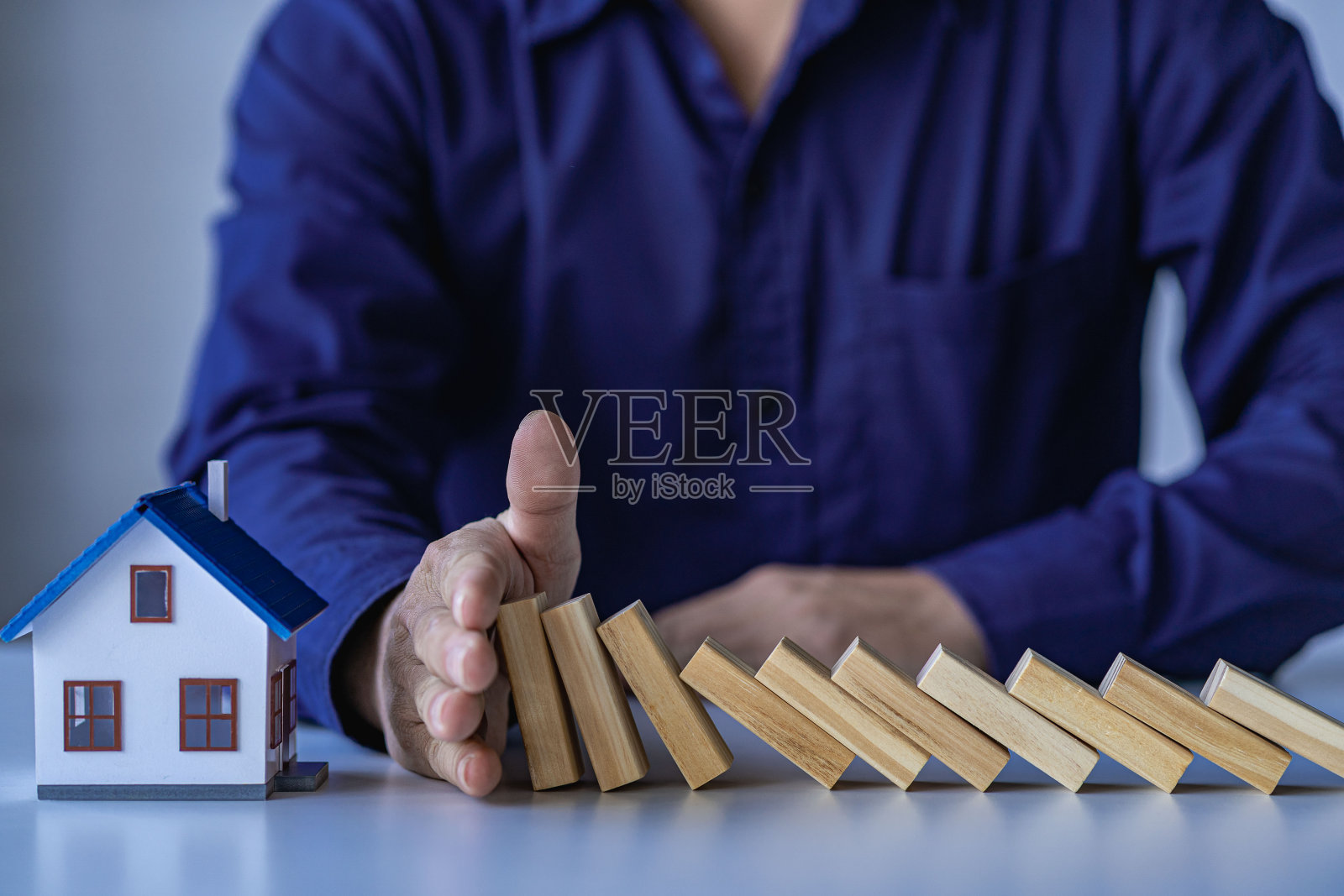 商人手握房屋风险与木块和安全投资和保险有关的房地产和财产照片摄影图片