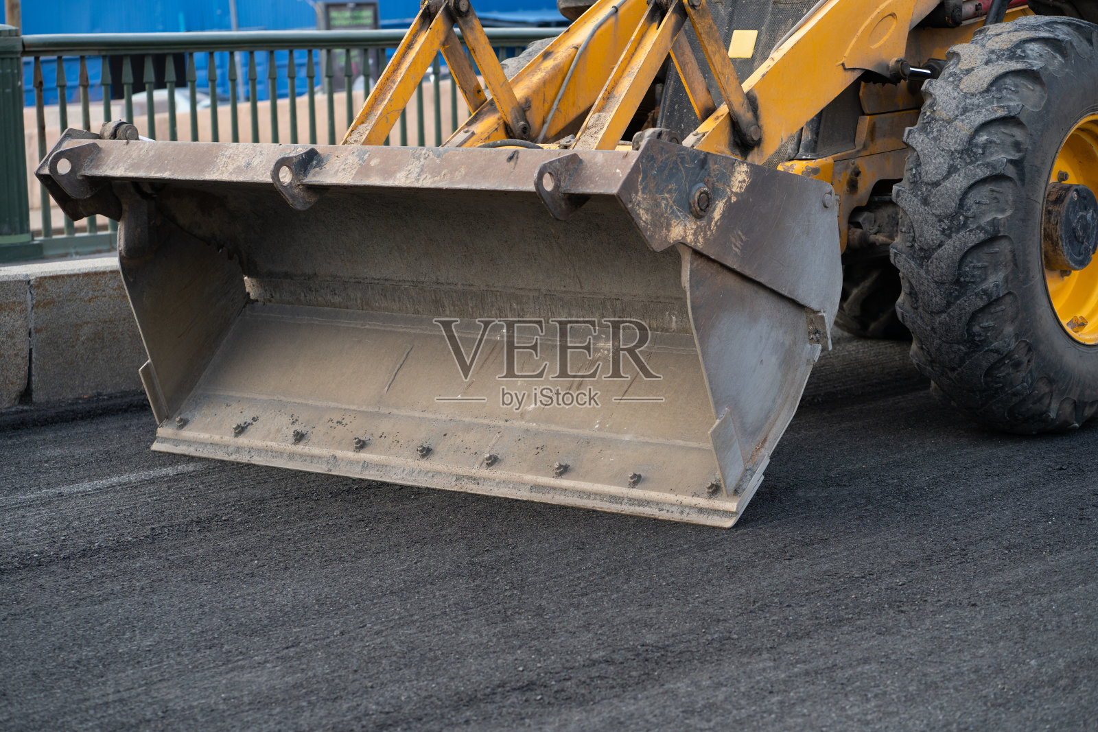 在准备铺设沥青的地面上，用挖掘机空斗行驶修复机动车路照片摄影图片