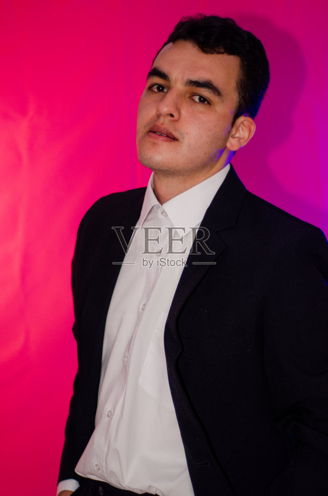 优雅的男人看着相机与彩色背景照片摄影图片