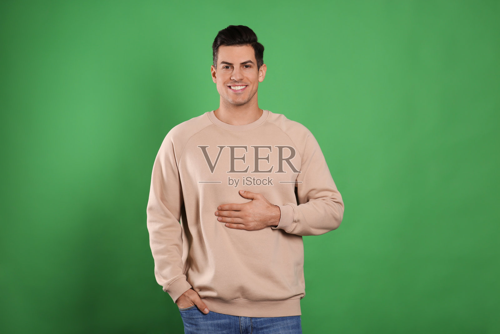 快乐的健康男子触摸他的腹部在绿色背景照片摄影图片