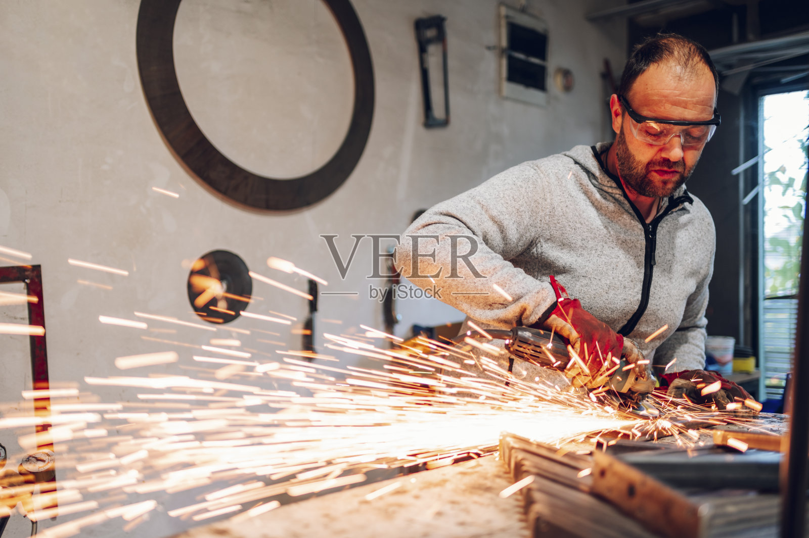 工厂里用磨床磨金属的工人照片摄影图片