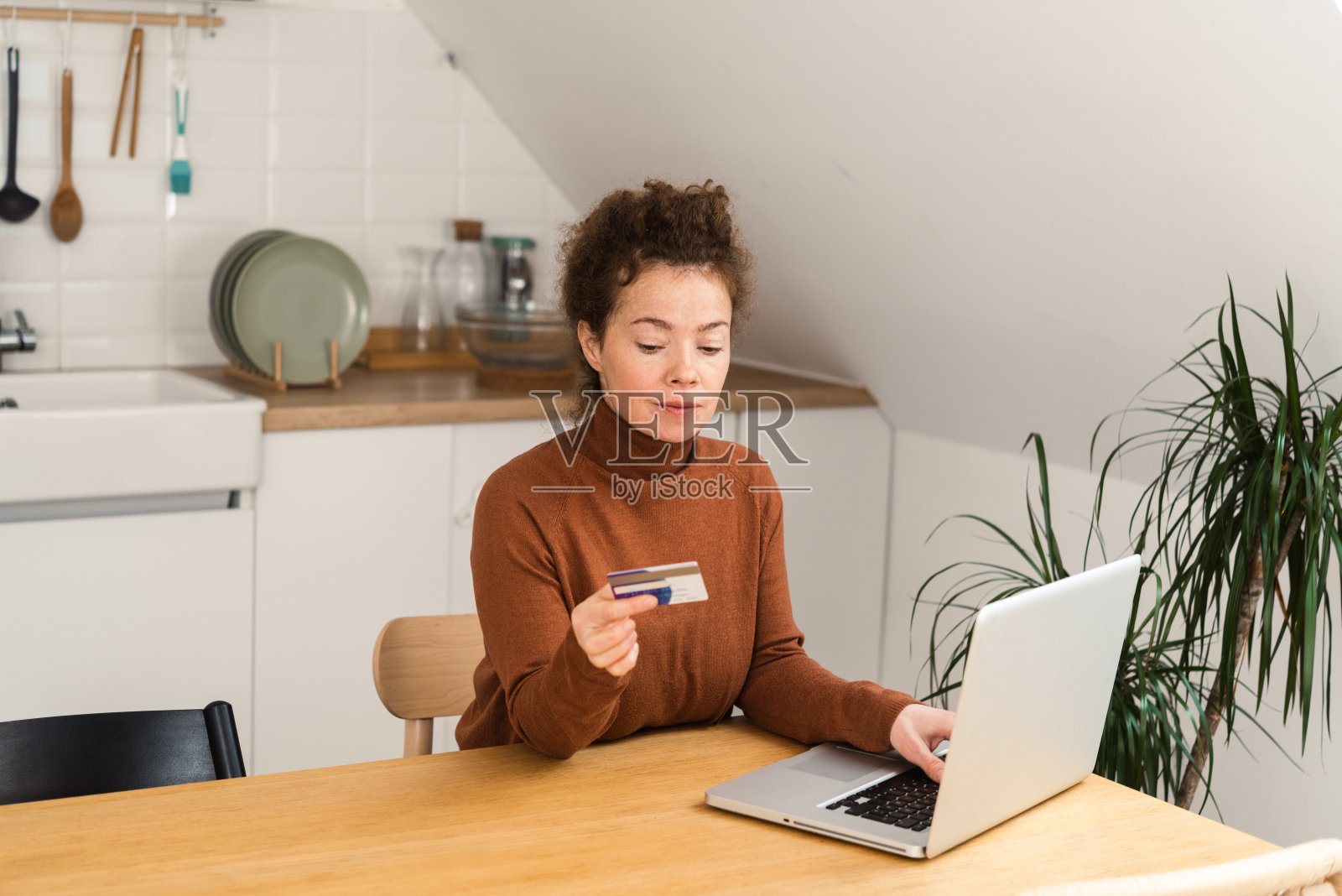 一个快乐的年轻女子的肖像享受在家里和网上购物照片摄影图片