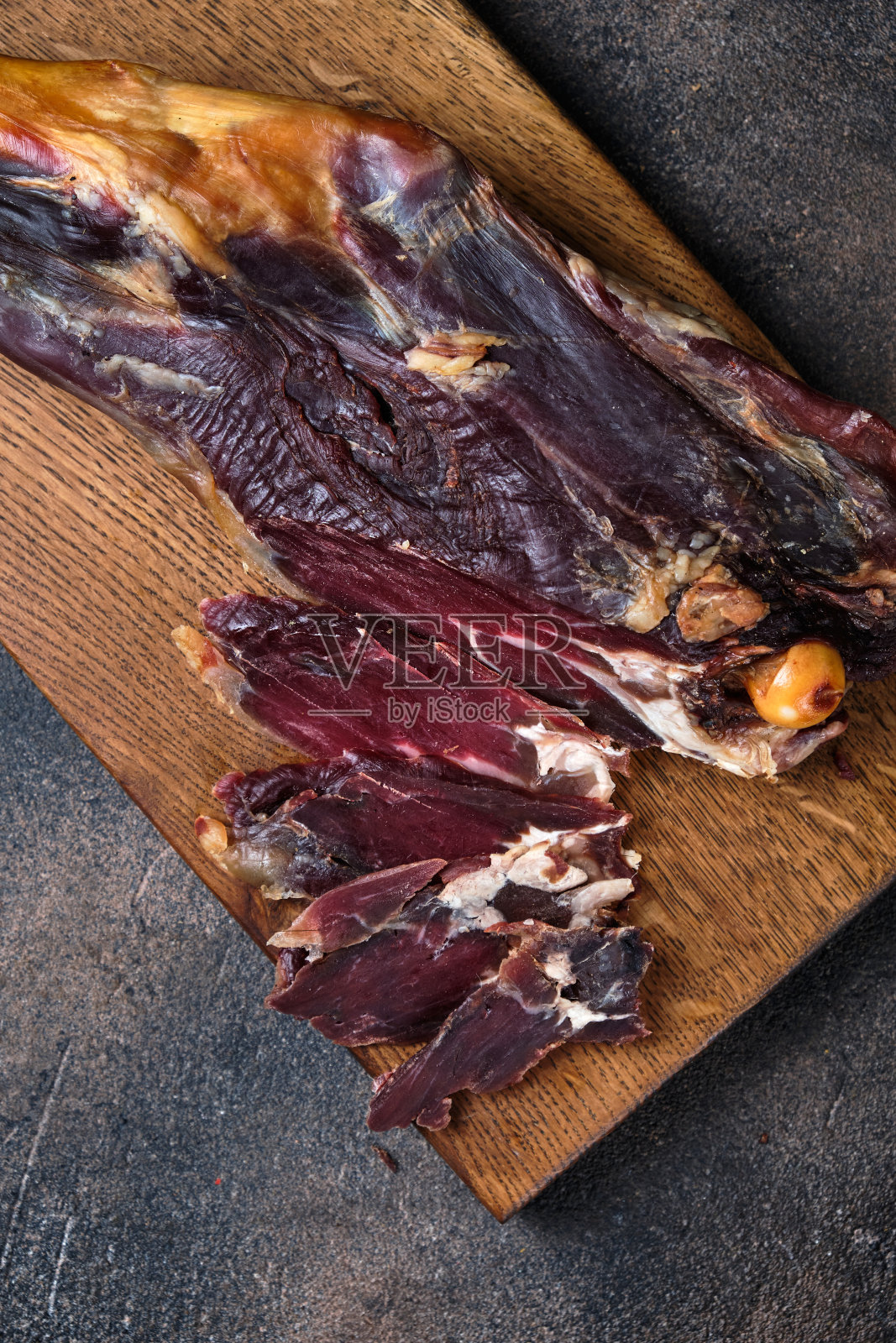 在木板上切烟熏羊腿照片摄影图片