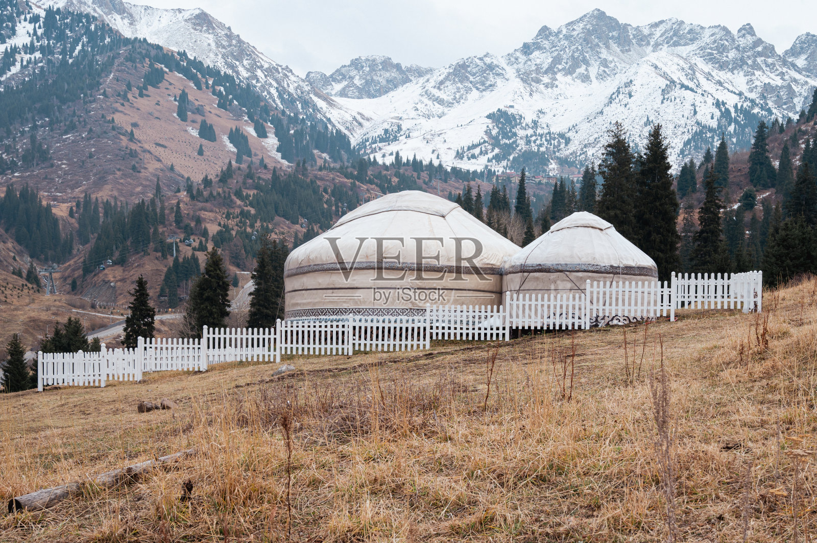 哈萨克斯坦山区以雪山为背景的传统蒙古包照片摄影图片