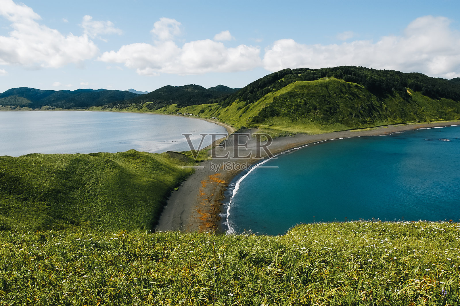 在群山的背景下，可以看到一个小沙嘴和两个海湾。照片摄影图片