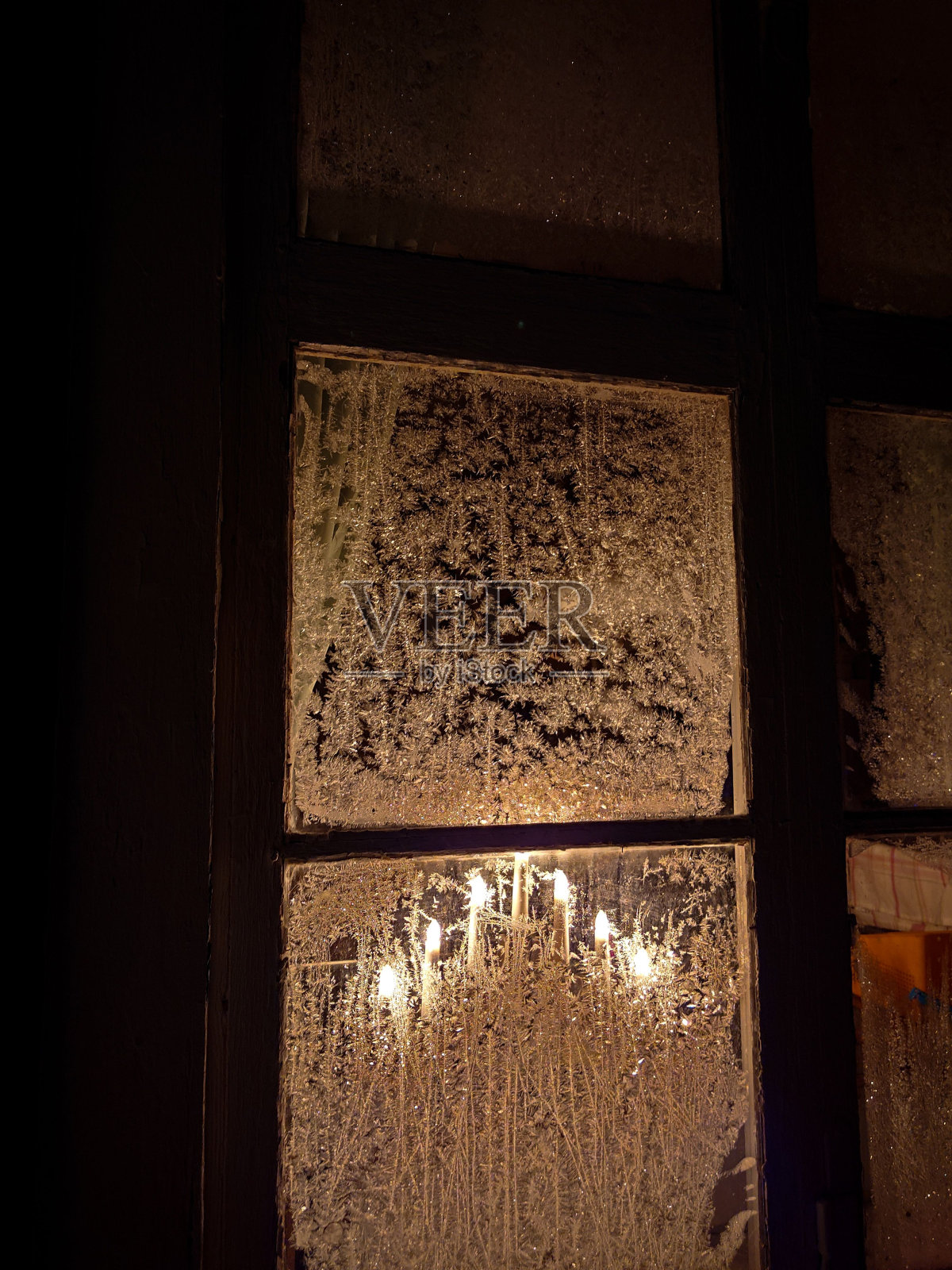 垂直特写的一个结霜的圣诞窗户与光从它照片摄影图片