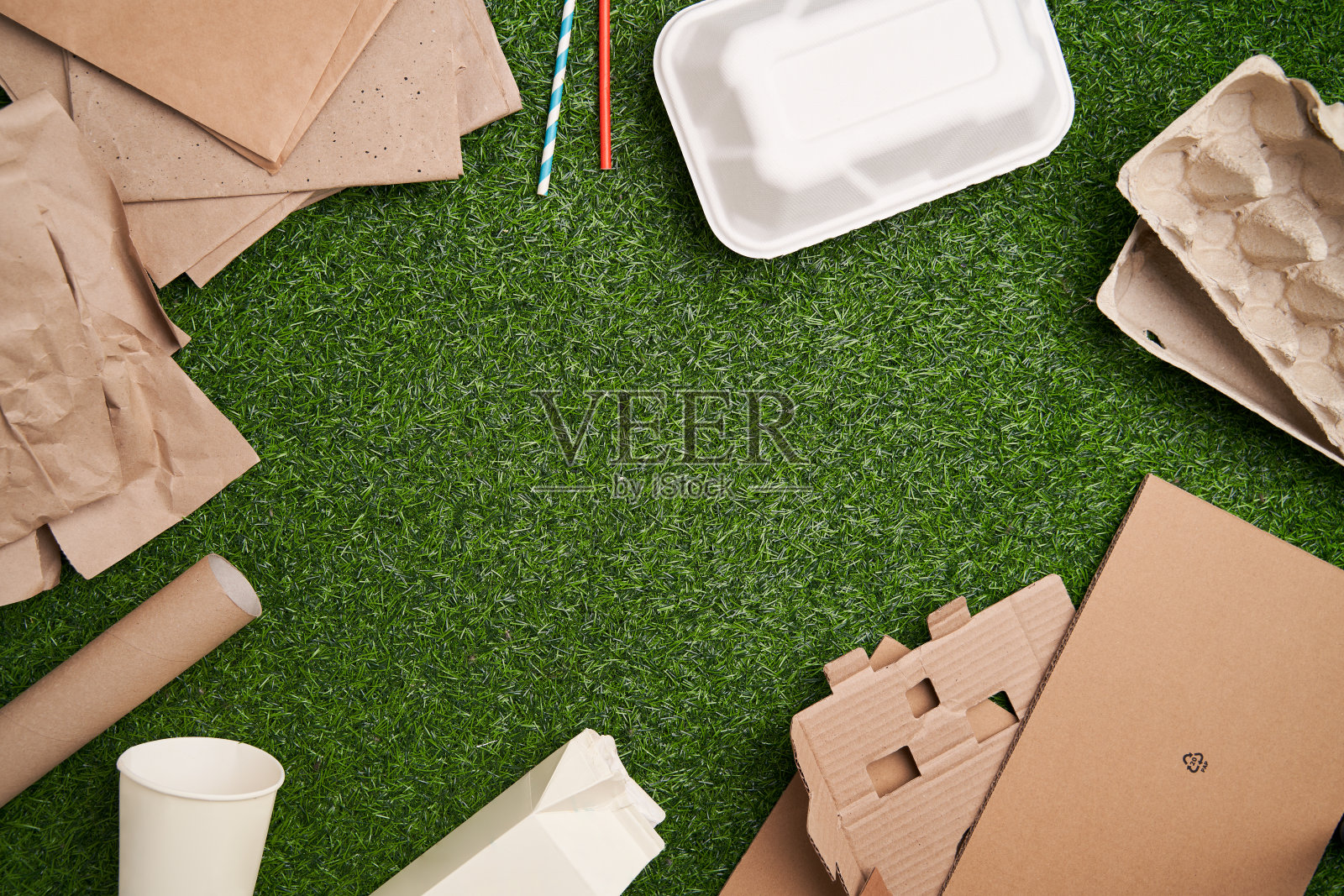 以绿色草地为背景的废纸回收利用。照片摄影图片