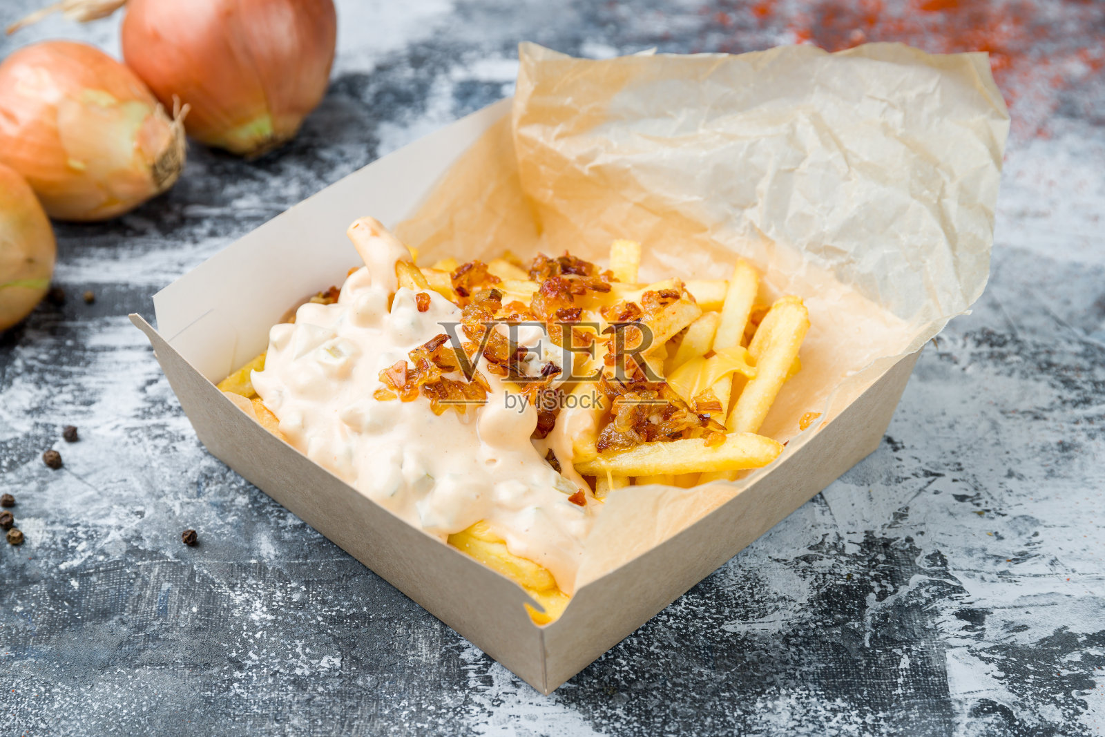 灰色的桌子上放着芝士酱薯条照片摄影图片